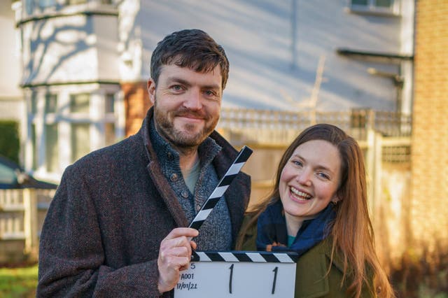 <p>Burke and his co-star Holliday Grainger on the set of ‘Strike’ in 2022</p>