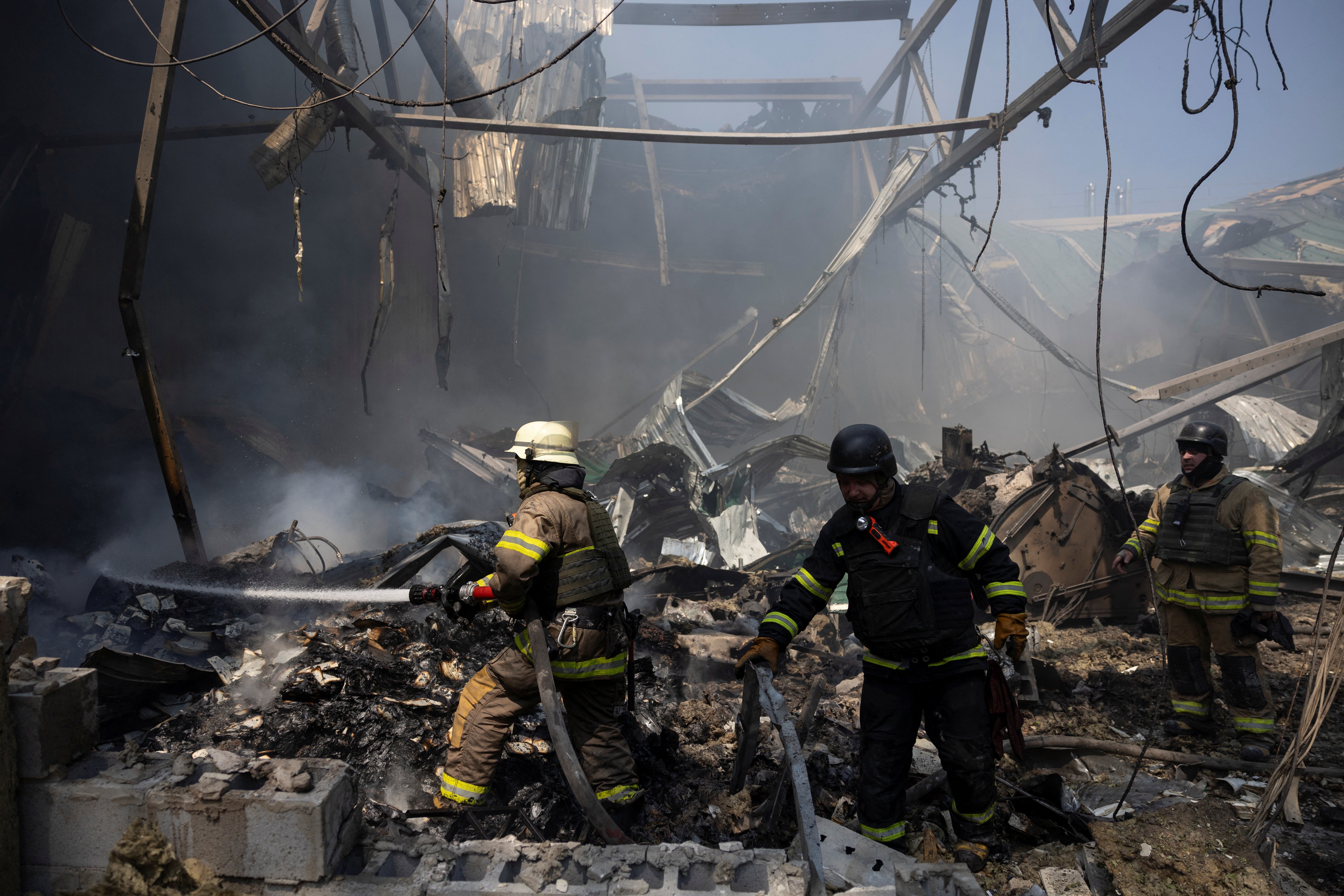Firefighters work at the site where a printworks was hit by Russian missile strikes