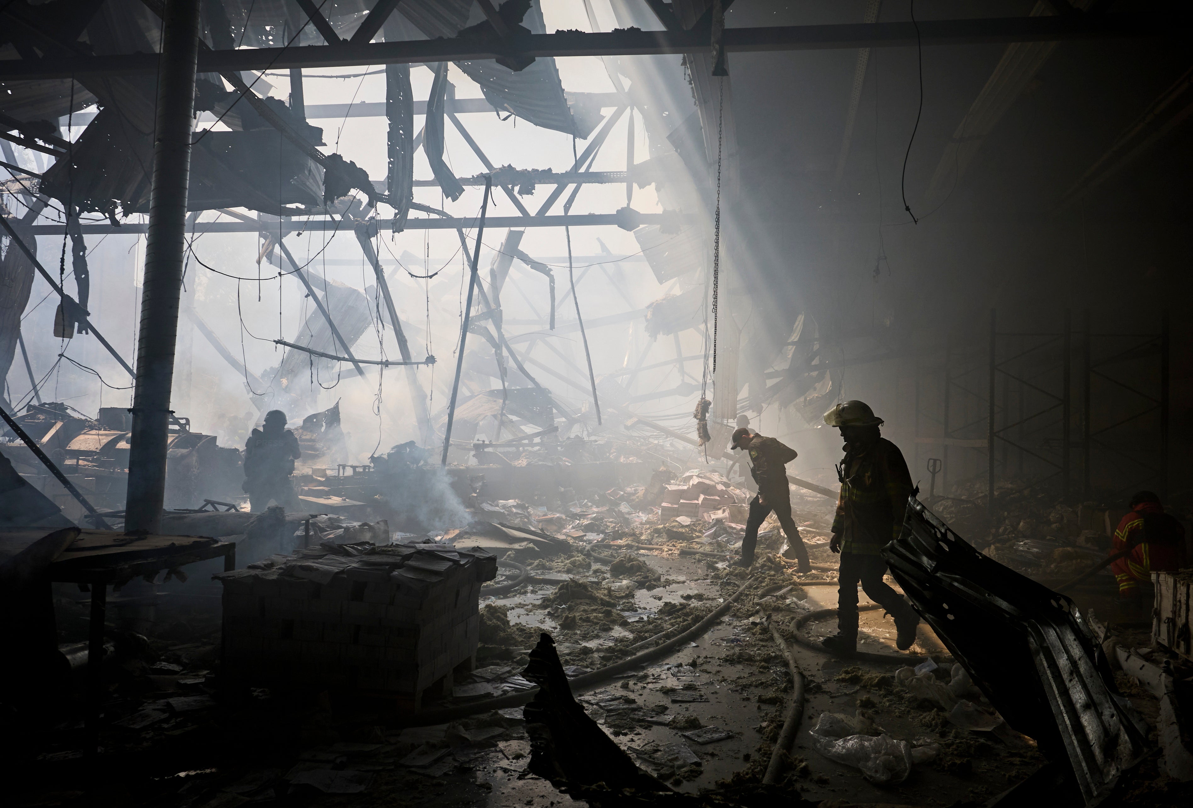 Ukrainian rescuers work at the site of a shelling on the printing business in Kharkiv
