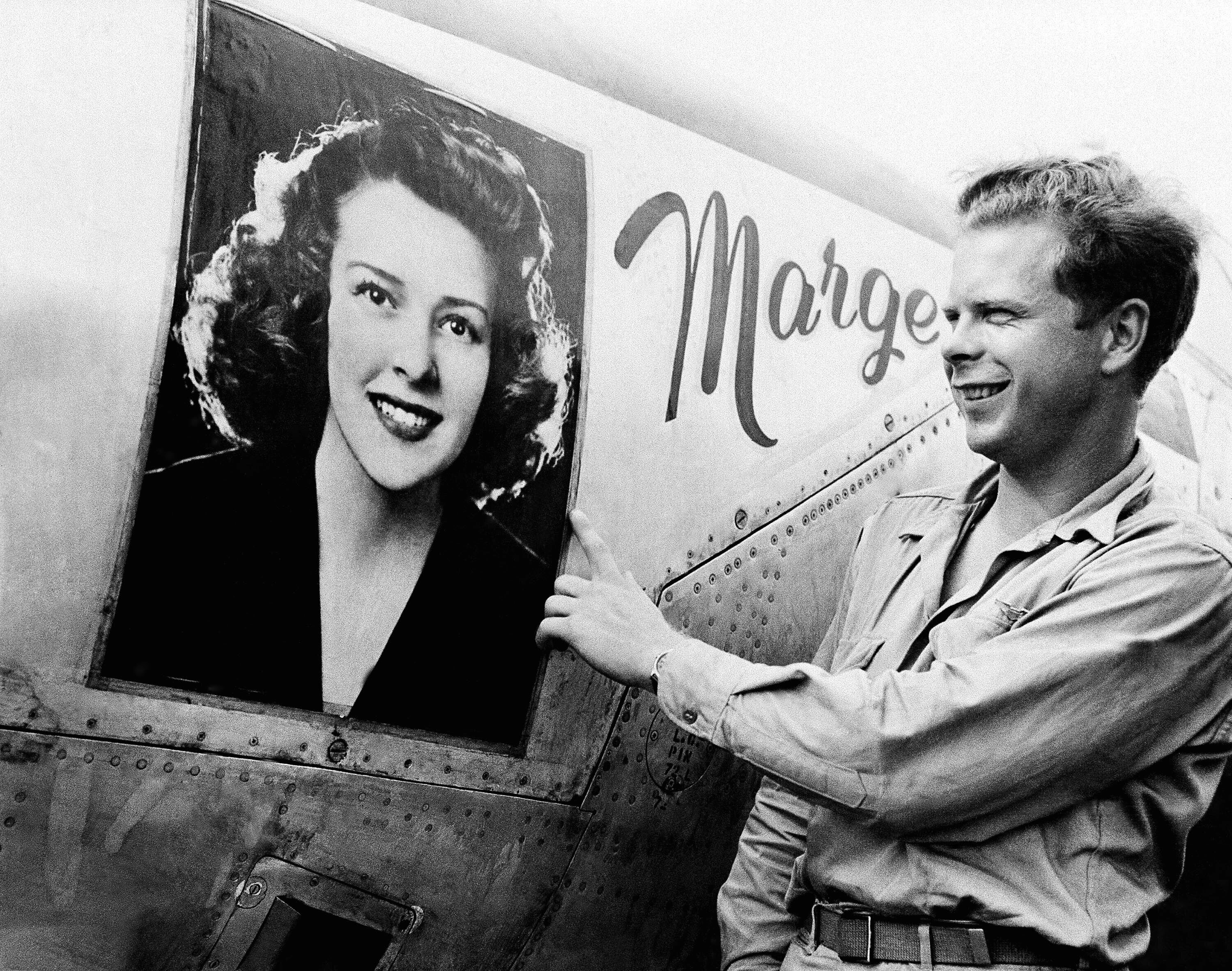 Captain Richard Bong points to a large picture of his girl friend, Marge Vattendahl, on his Lighting P-38 fighter plane pilot stationed at a New Guinea Air Base, March 31, 1944