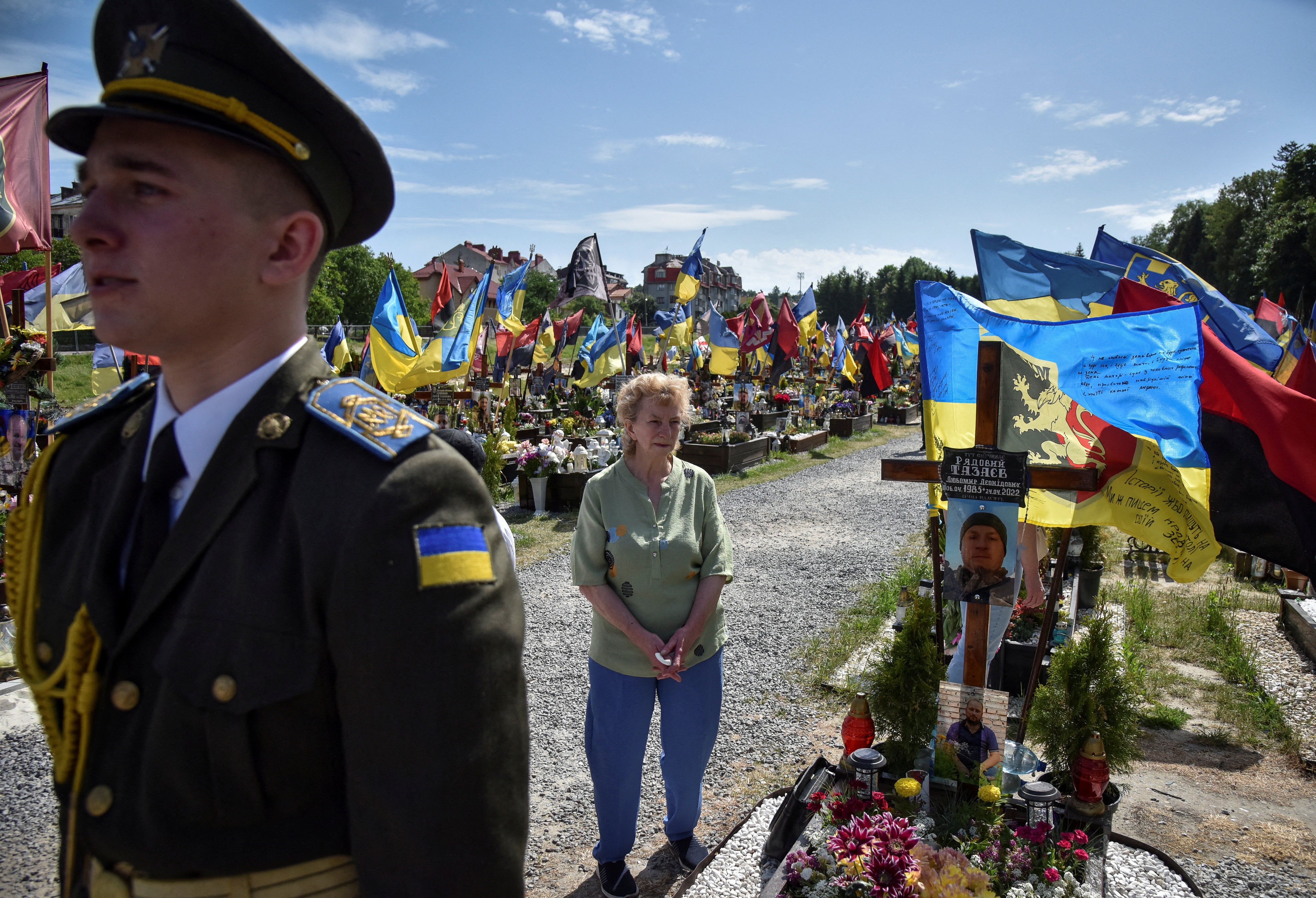 A woman reacts as she visits the grave of her relative, a killed Ukrainian defender, at the Lychakiv cemetery in Lviv, western Ukraine