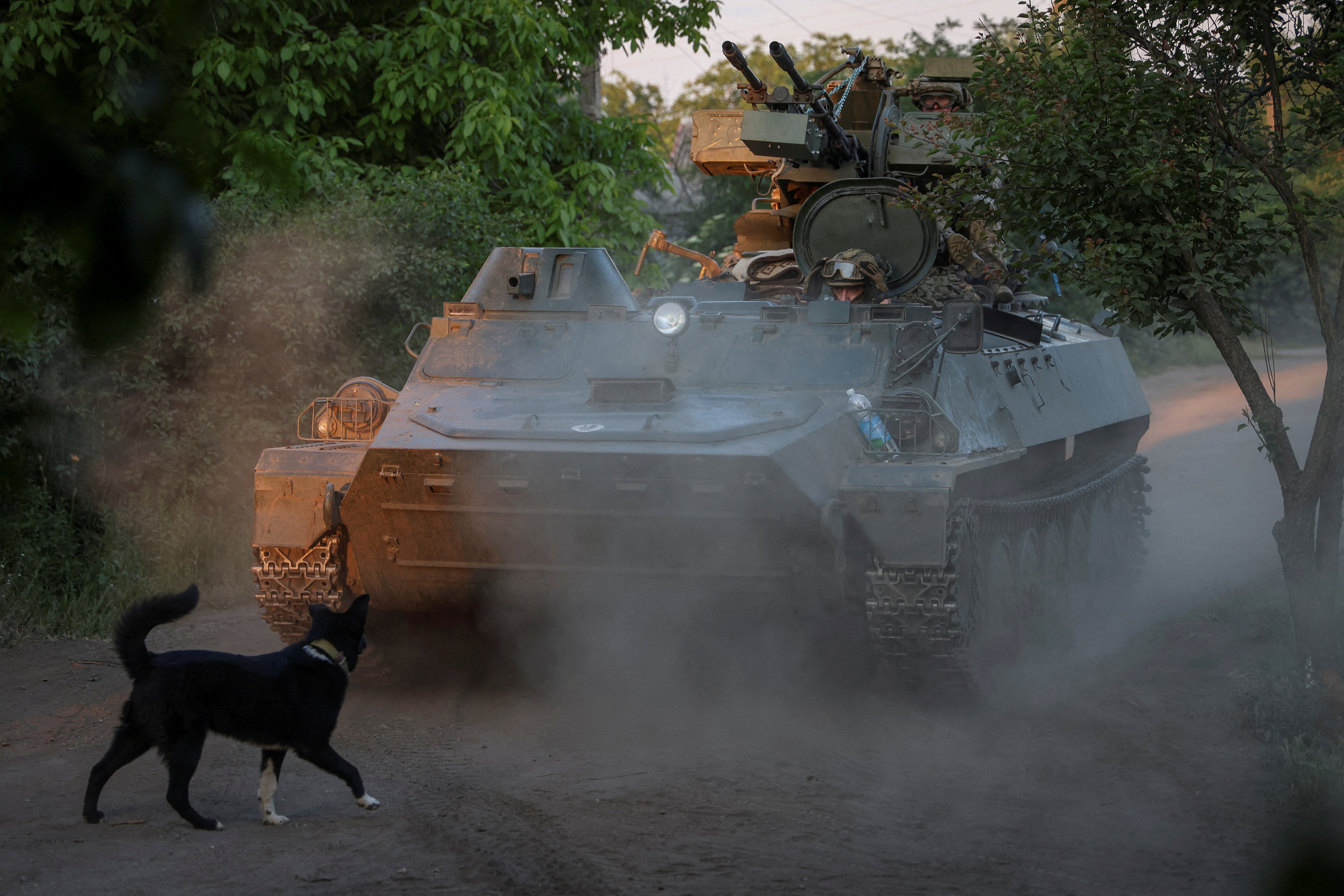 A Ukrainian serviceman from an air defence unit of the 93rd Mechanised Brigade rides in an armoured personnel carrier (APC) with an anti-aircraft cannon near Bakhmut