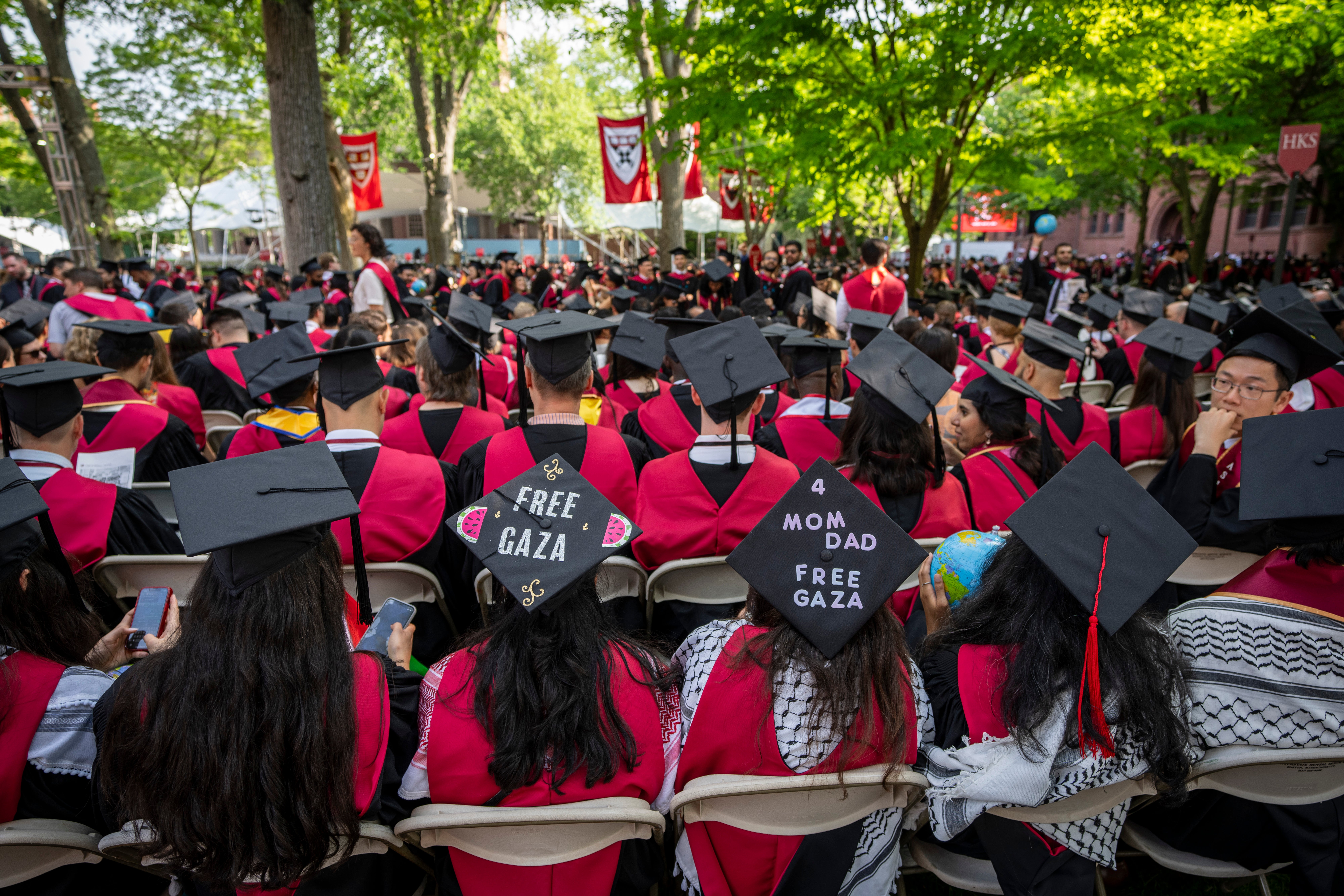 Graduating students with messages supporting Gaza on their mortarboards during commencement in Harvard Yard