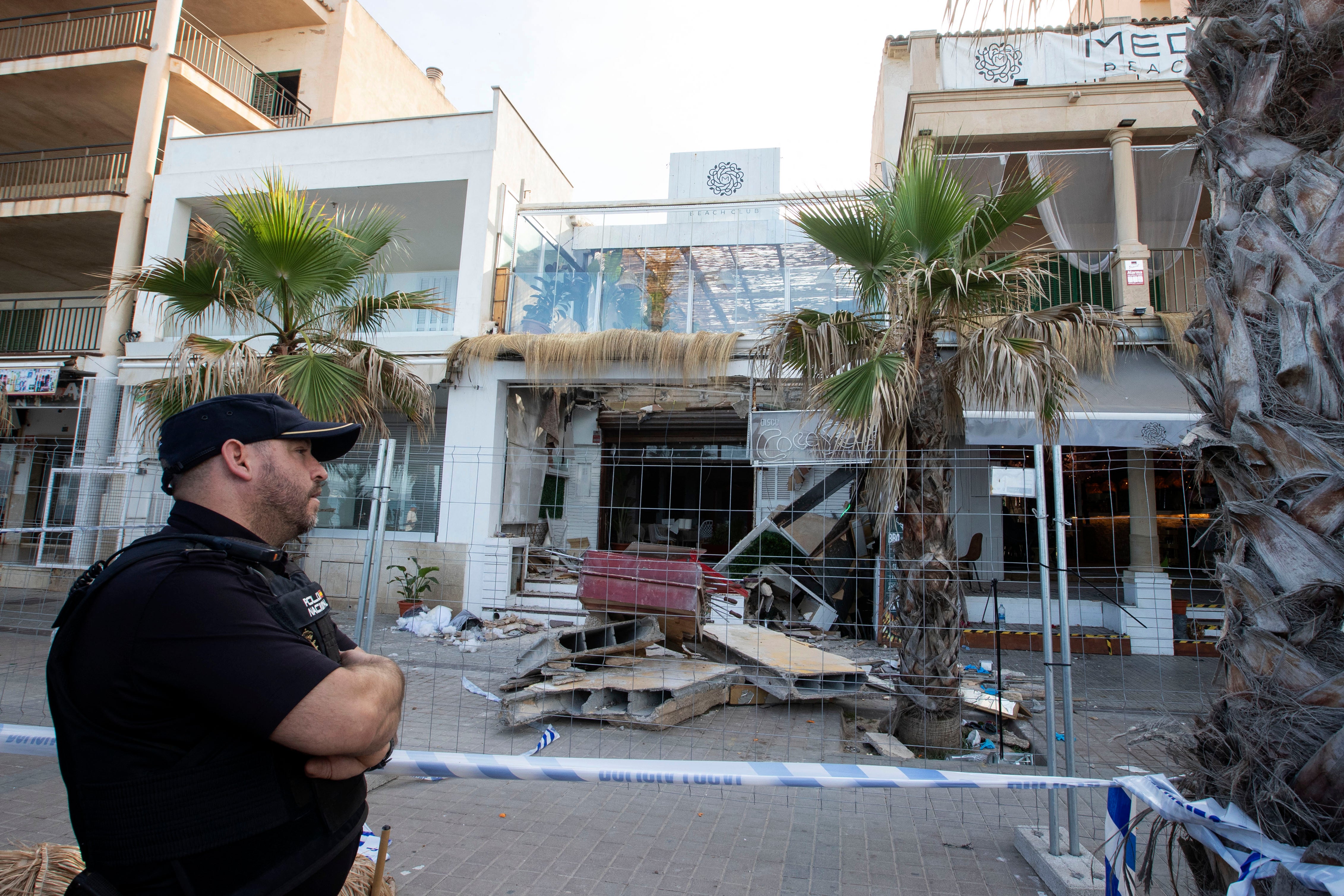 A police officer stands during investigation works one day after a two-storey restaurant collapsed