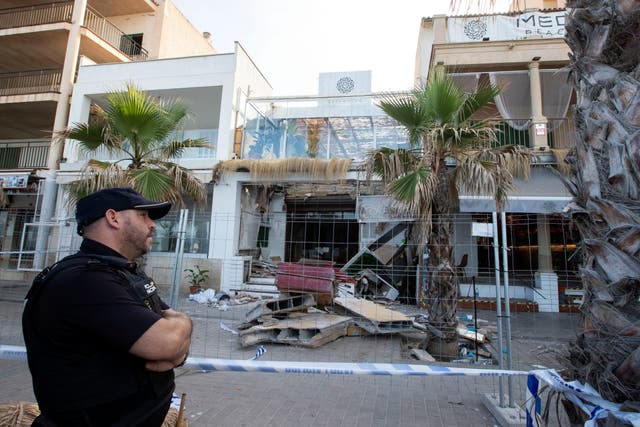 <p>A police officer stands during investigation works one day after a two-storey restaurant collapsed</p>