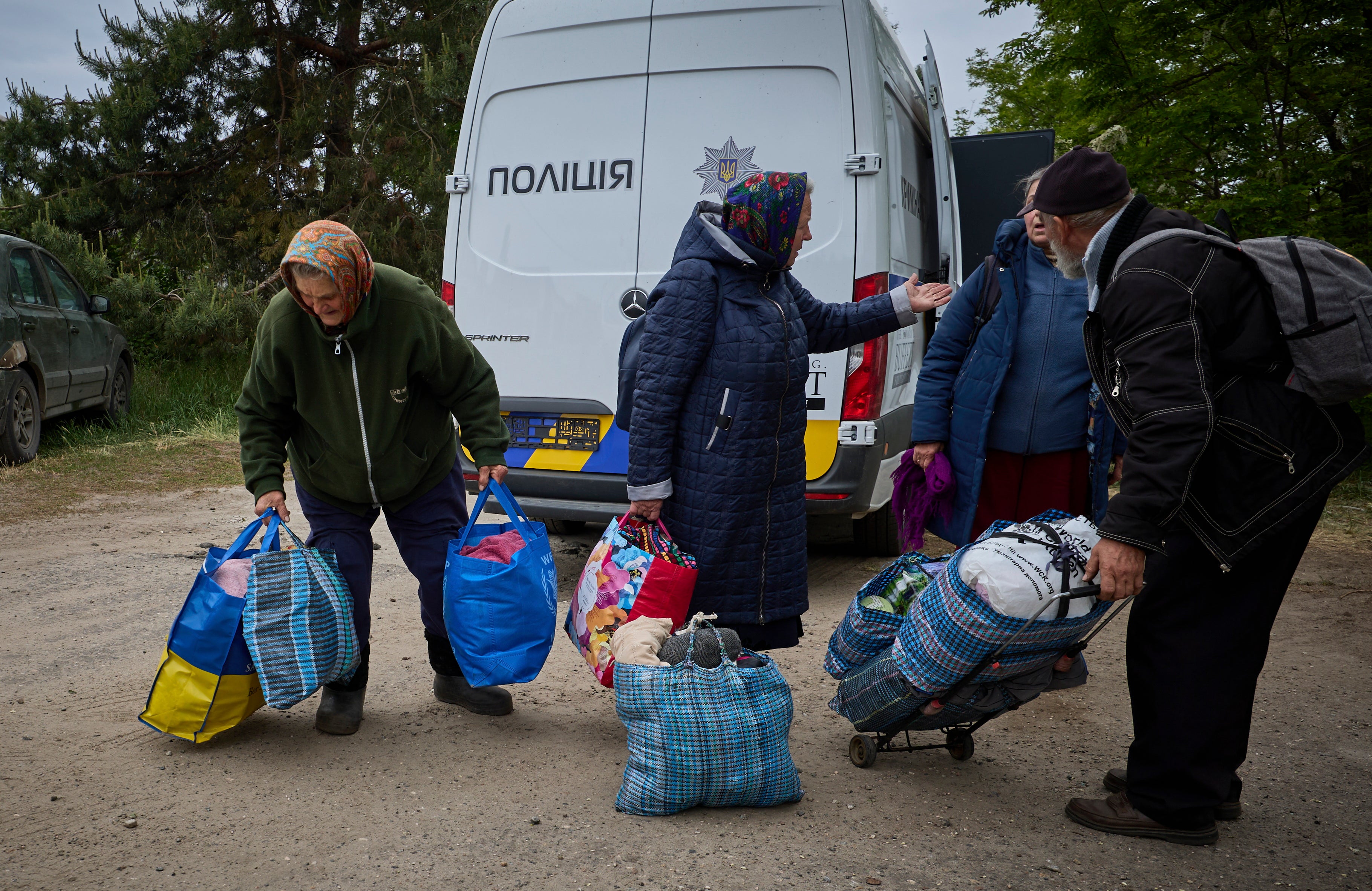 People gather at a mobile evacuation center for evacuees from different territories near the border with Russia, at an undisclosed location in Kharkiv's area