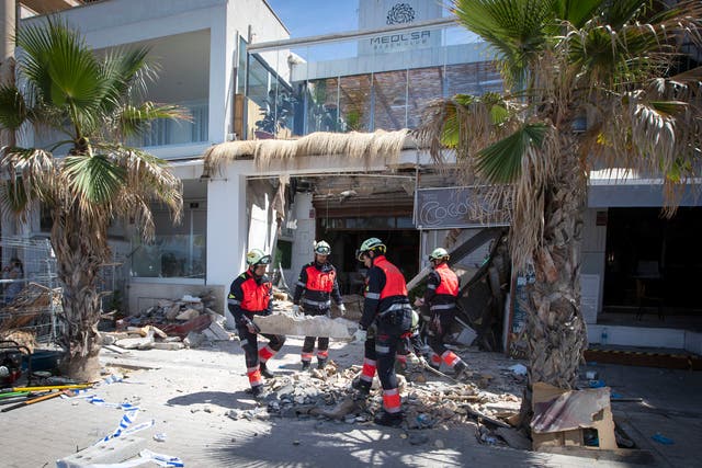 <p>Firefighters work at the scene one day after the two-storey restaurant collapsed</p>