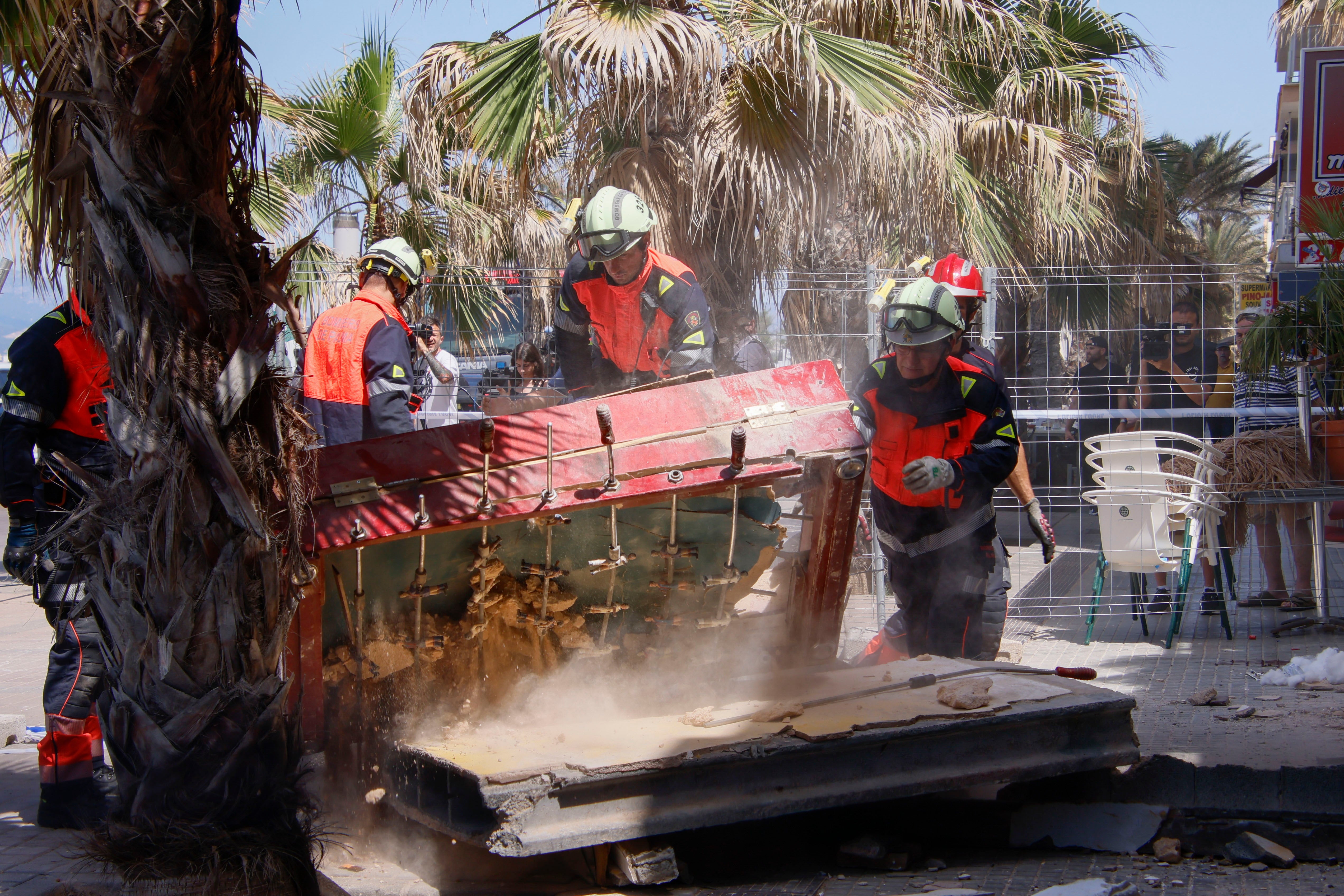 Spanish firefighters search the site after a restaurant collapsed last night