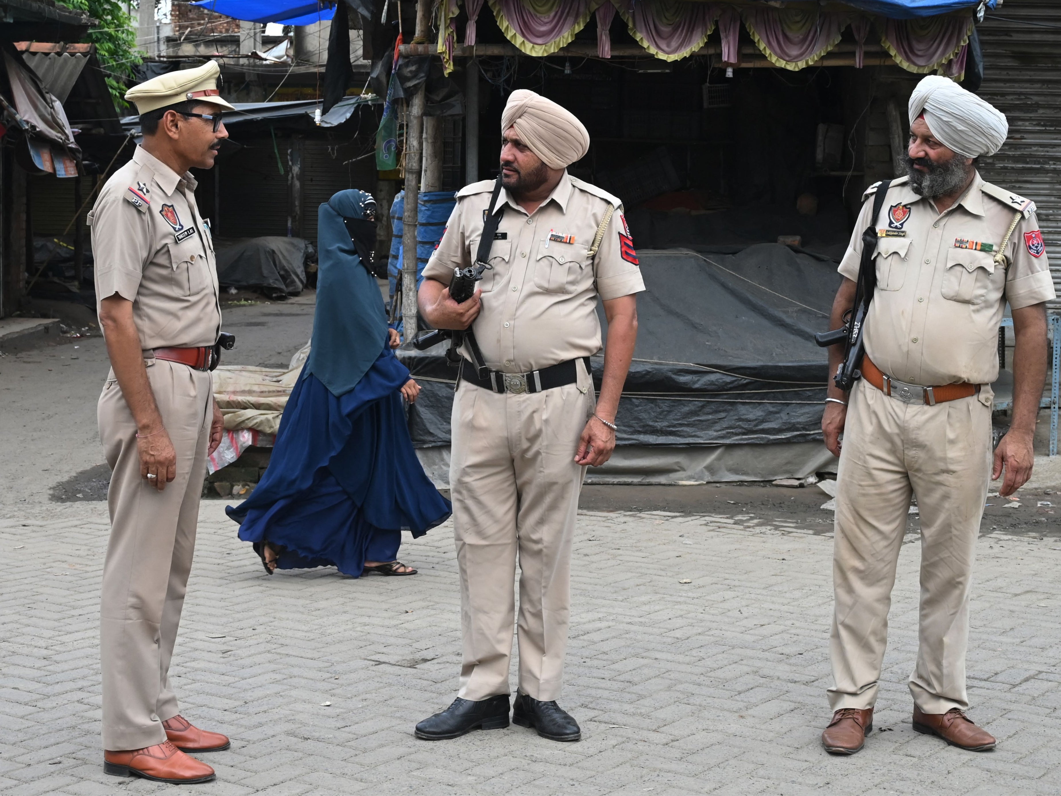 File. Police officers stand guard along a road on the outskirts of Kolkata on 12 July 2023
