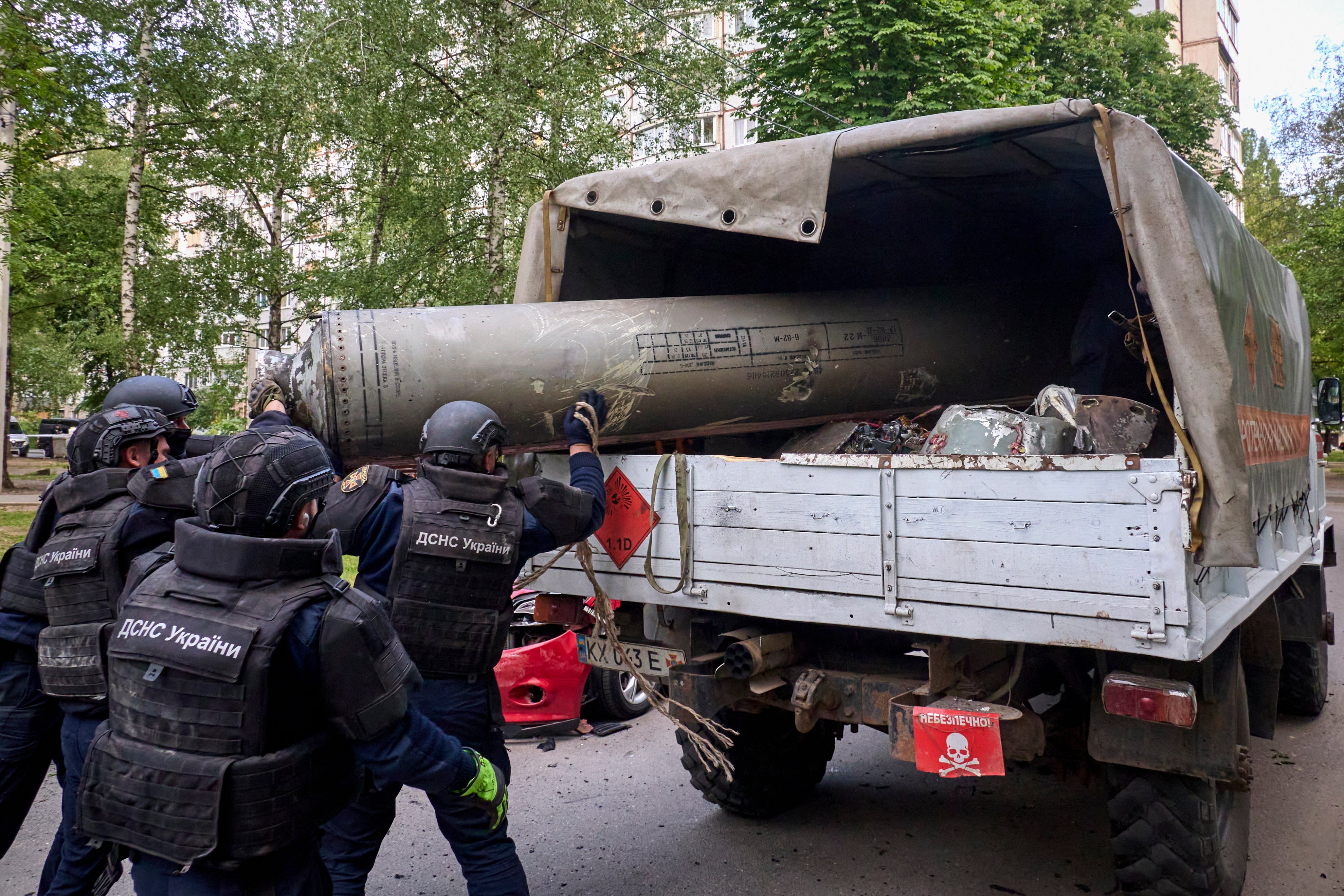 Ukrainian rescuers load debris of a Russian S300 missile into a truck after the shelling of residential area in Kharkiv