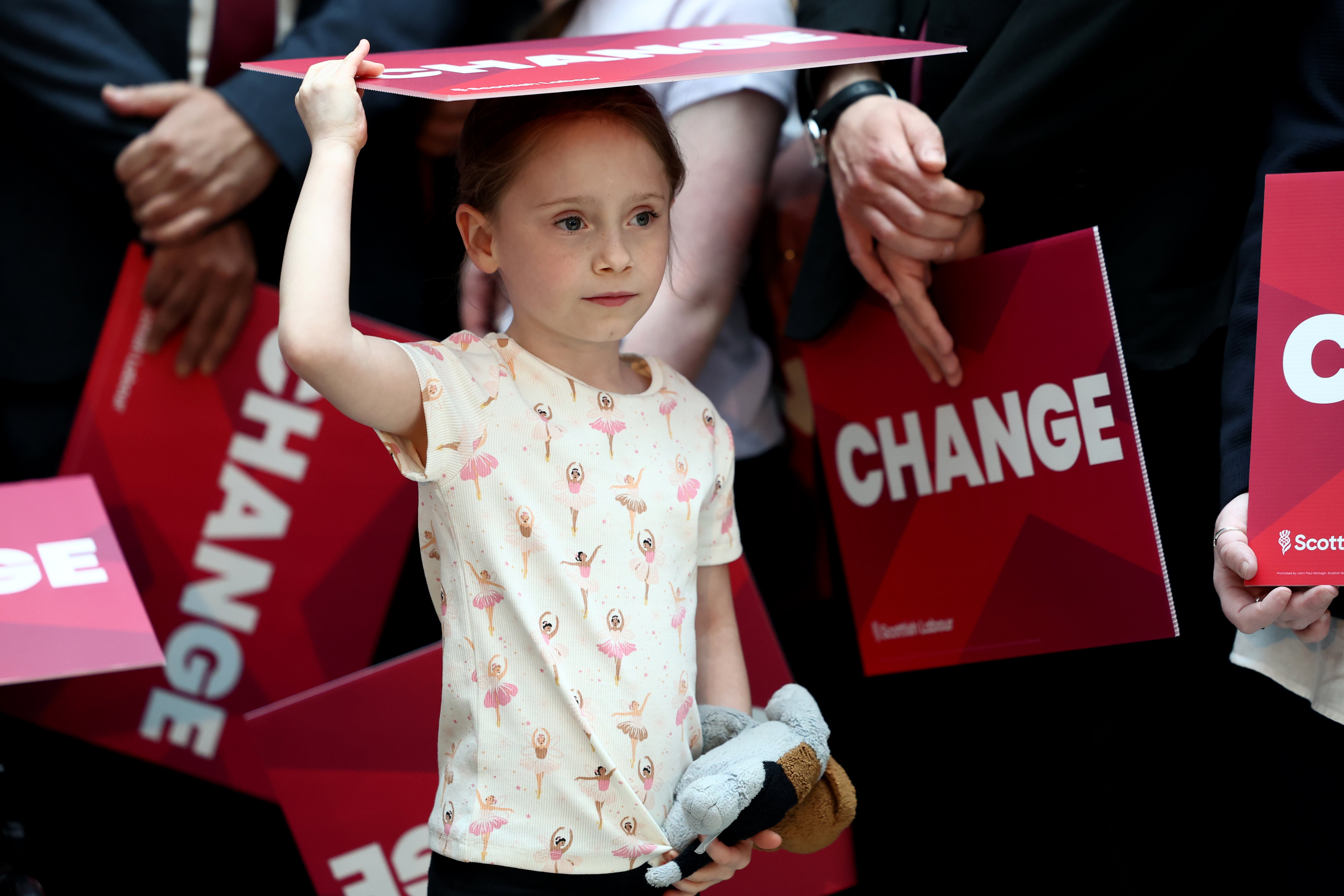 A young supporter holds a sign reading "Change" as they wait for the launch of the Scottish Labour general election campaign at Caledonia House