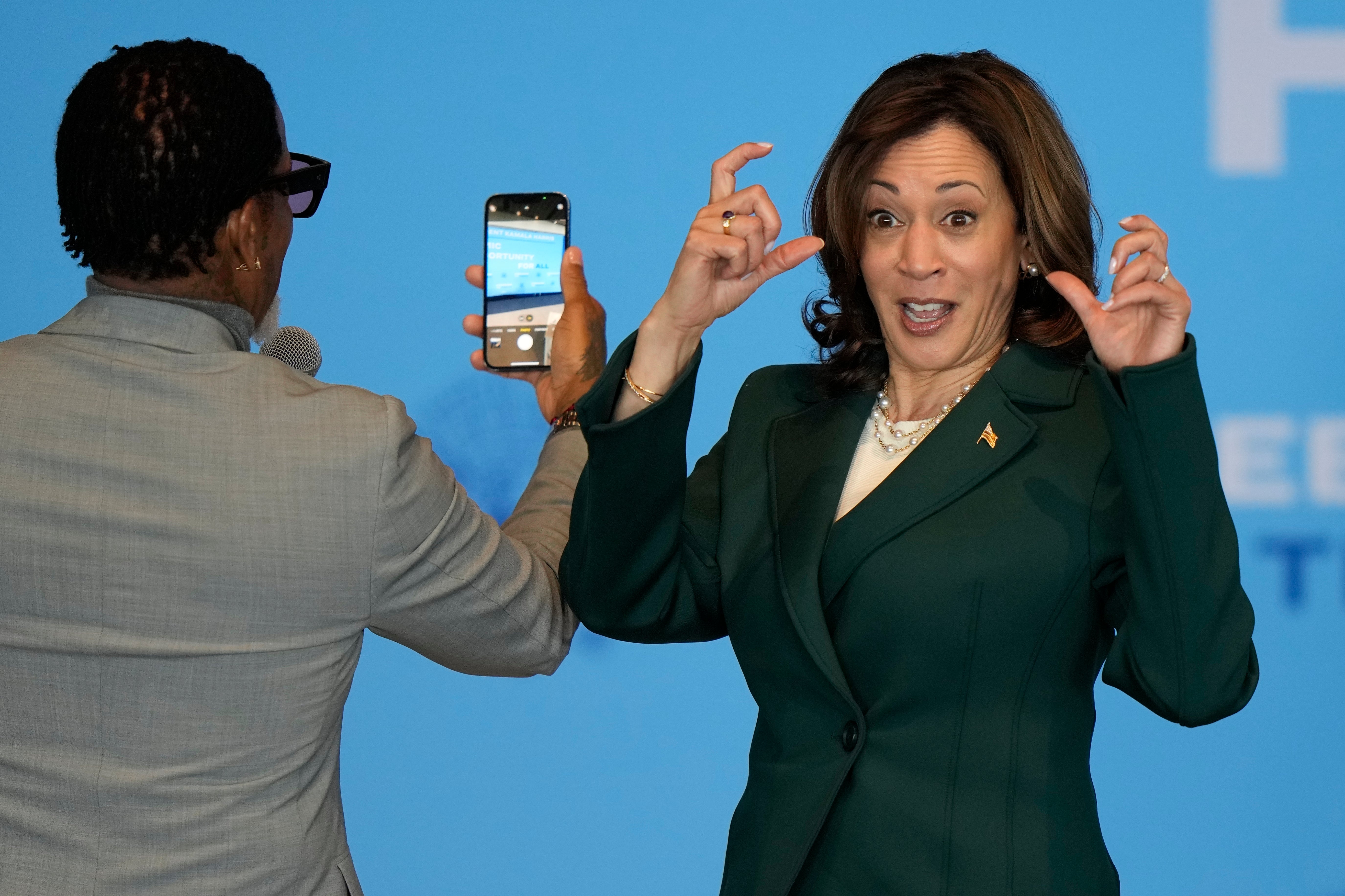 Vice President Kamala Harris and comedian and author DL Hughley take a selfie with the crowd during an event at Discovery World Thursday, May 16, 2024, in Milwaukee. (AP Photo/Morry Gash)