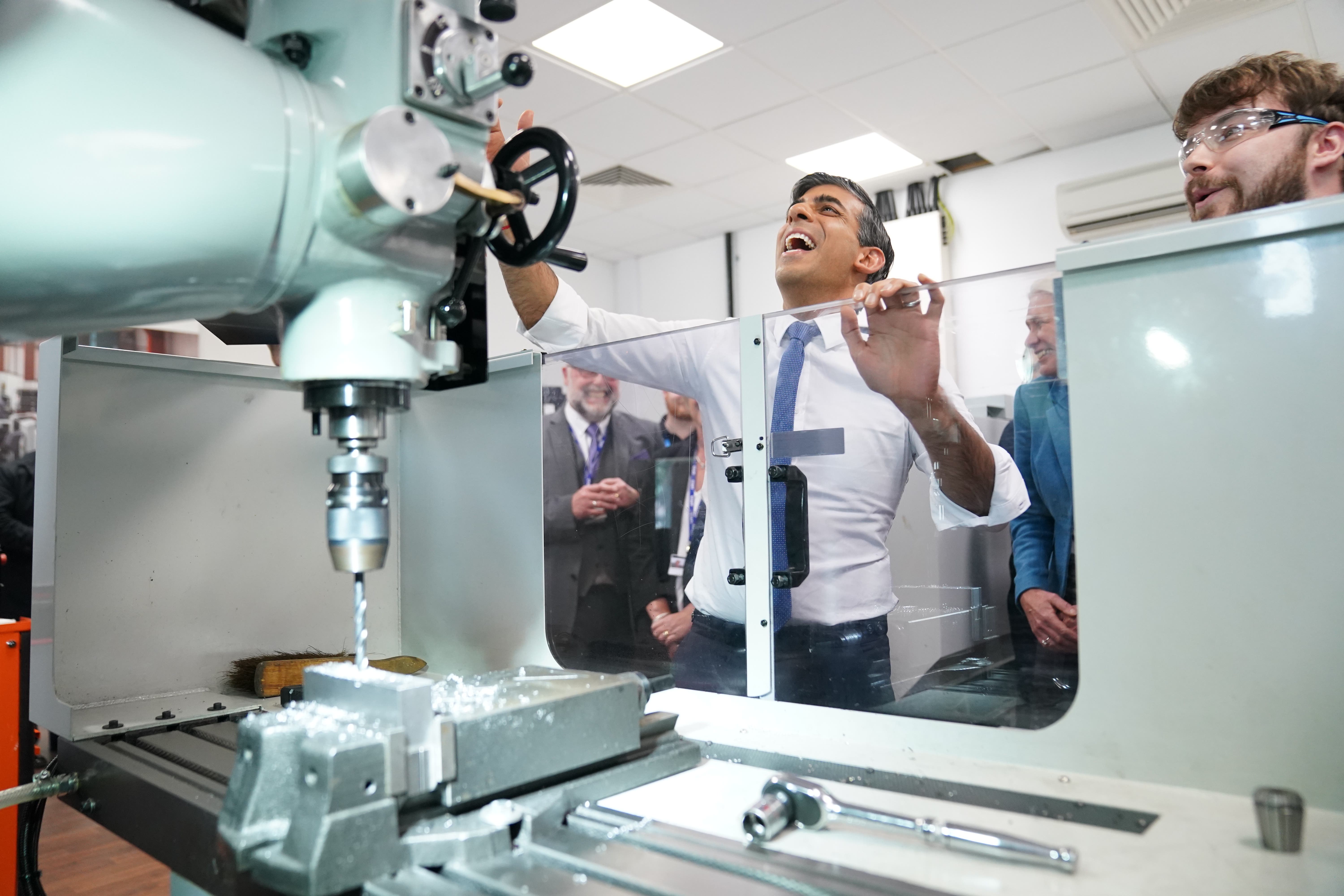 Rishi Sunak attempts to drill a hole in a piece of metal in the Mechanical Engineering Lab during a visit to Cannock College in the West Midlands on Friday (Stefan Rousseau/PA)