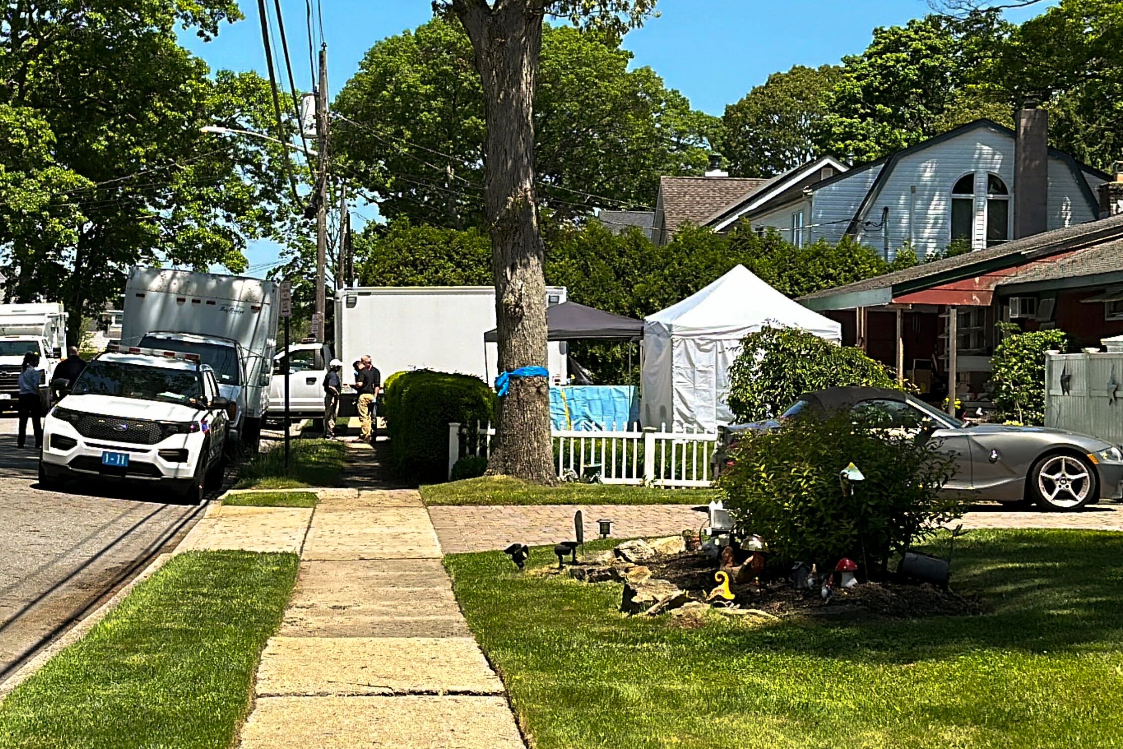 Suffolk County police stand outside the Massapequa Park home of Rex Heuermann on May 24, 2024 as a second exhaustive search comes to an end after six days