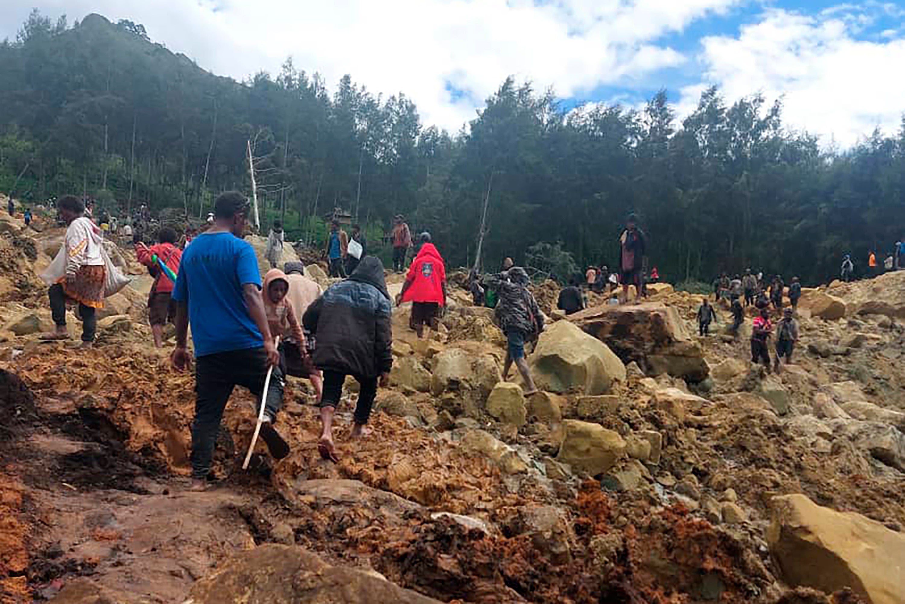 People cross over landslide area in Yambali village, Papua New Guinea