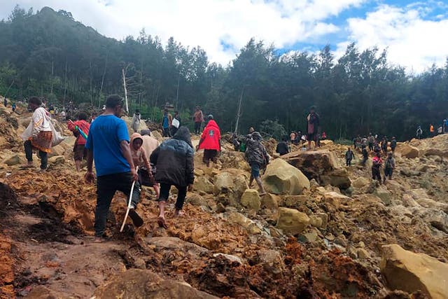 <p>People cross over landslide area in Yambali village, Papua New Guinea</p>
