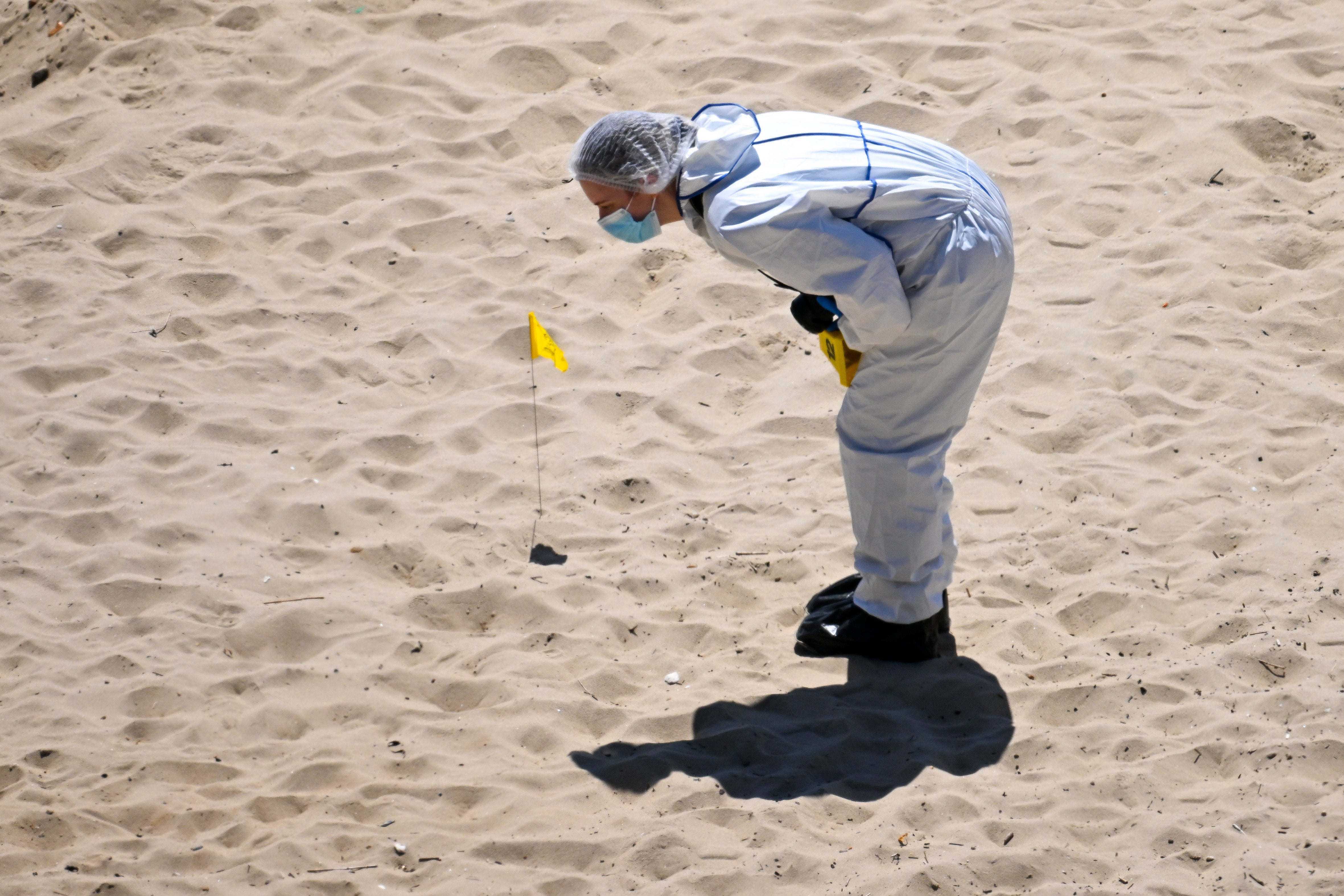 Forensic officers work at the scene of the double stabbing at Durley Chine Beach