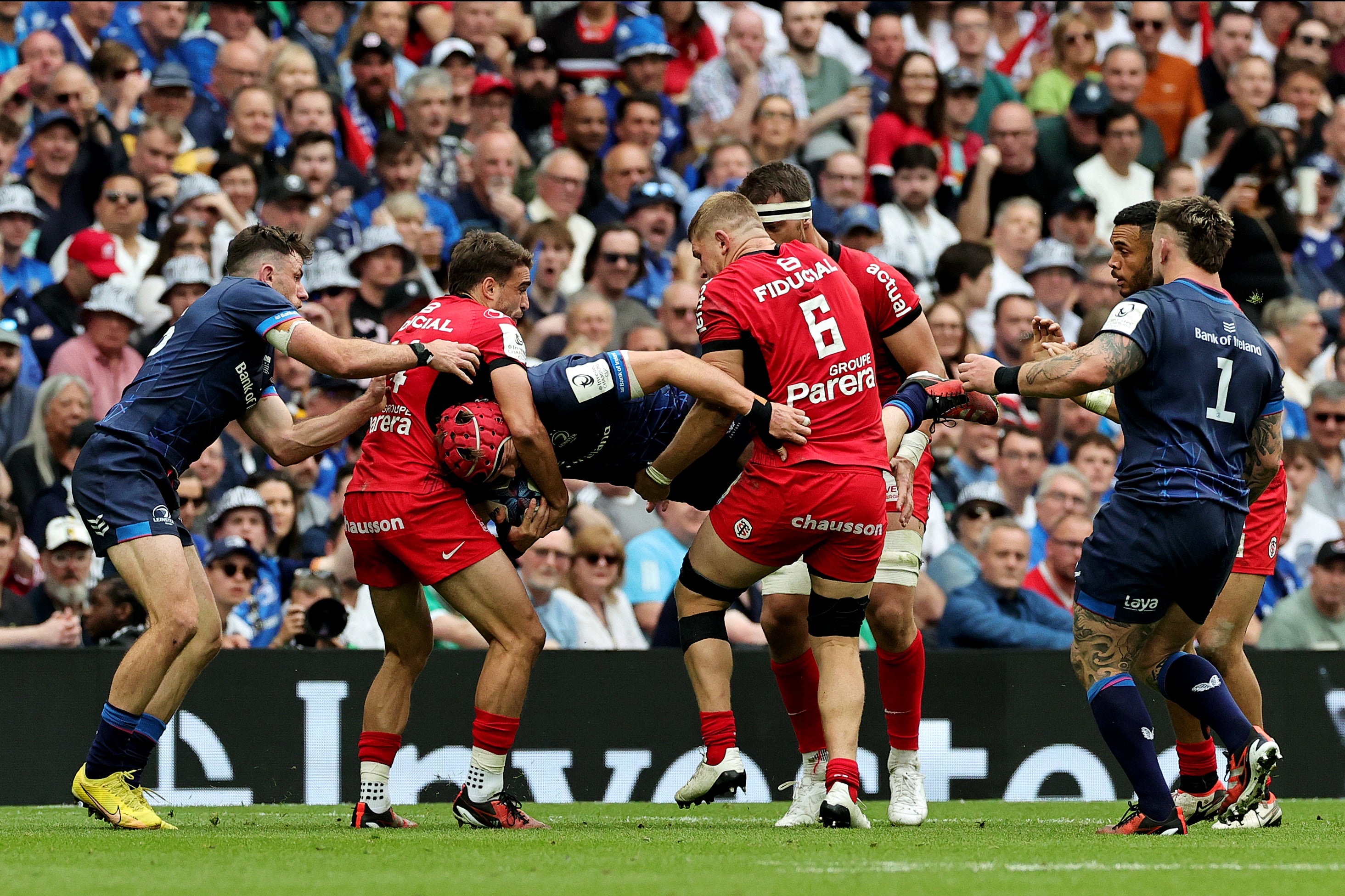 Josh van der Flier of Leinster is picked up by Juan Cruz Mallia and Jack Willis of Stade Toulousain