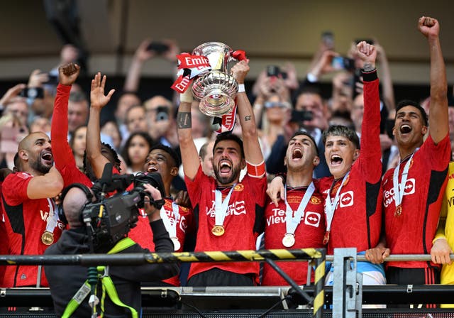 <p>Bruno Fernandes lifts the FA Cup trophy</p>