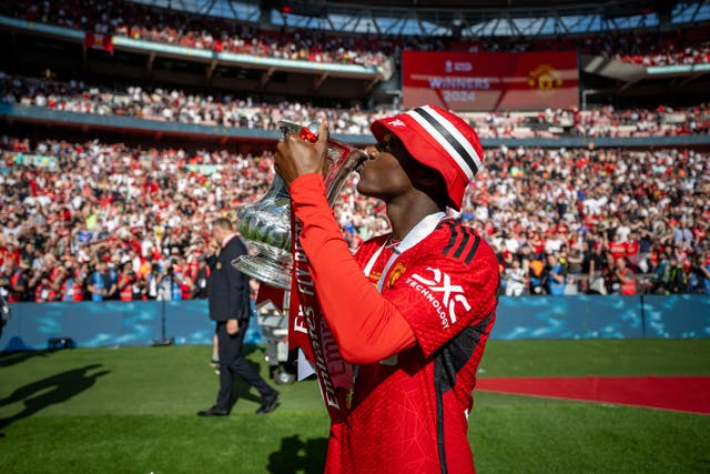 <p>Kobbie Mainoo kisses the FA Cup trophy</p>