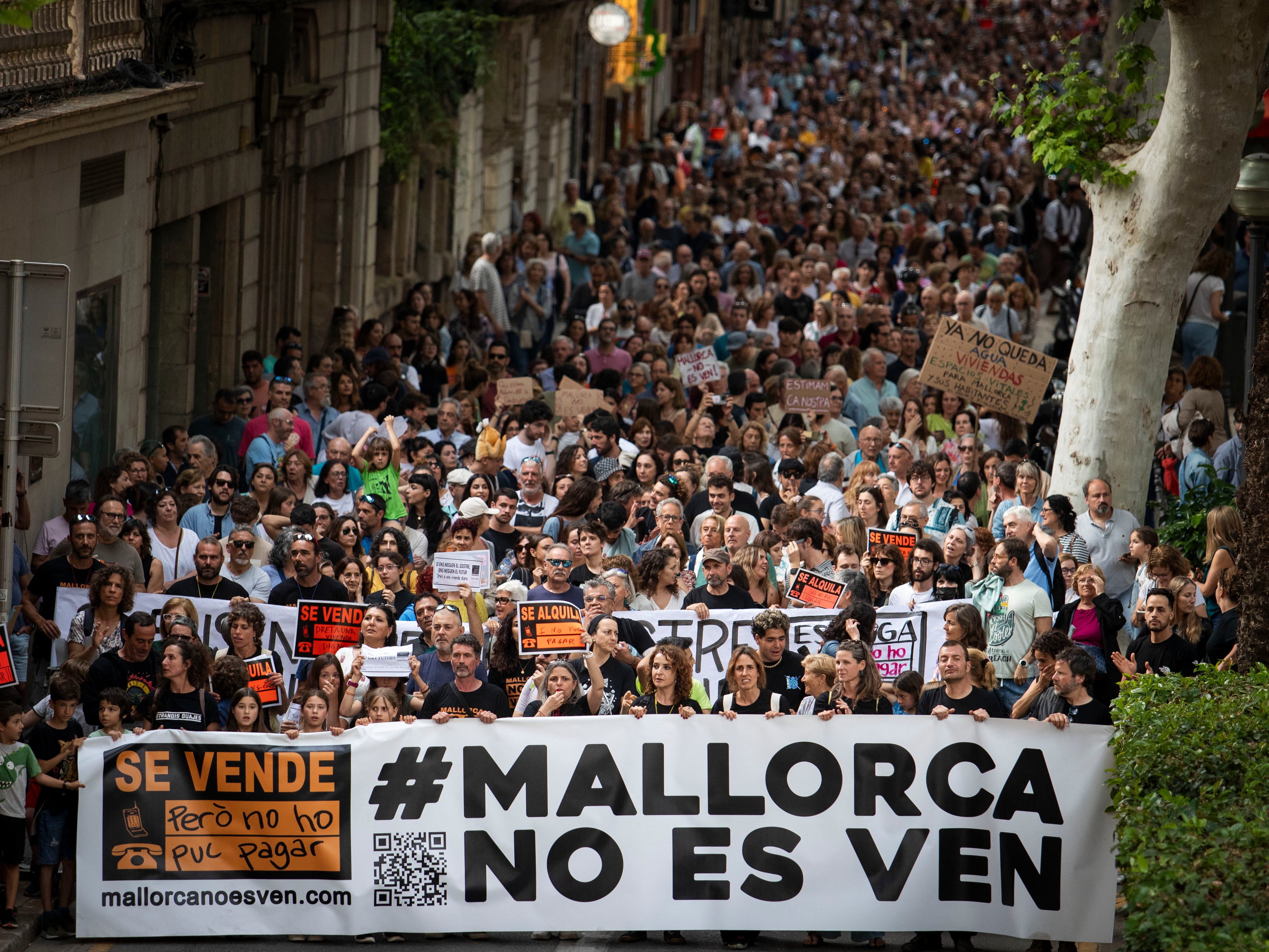 Protesters hold a banner reading “Mallorca is not for sale” during a demonstration to protest against the massification of tourism and housing prices on the island of Mallorca in Palma de Mallorca on May 25, 2024