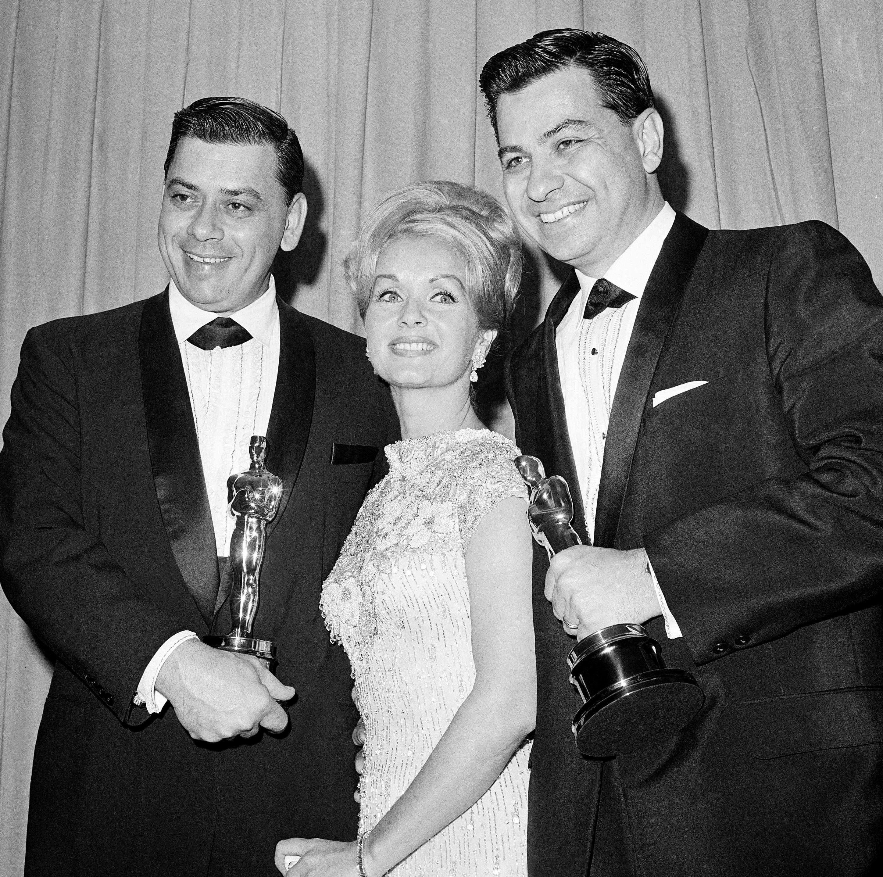 Debbie Reynolds poses with Richard M. Sherman, right, and Robert Sherman, left, who received the Academy Awards for Best Song and Best Score for ‘Mary Poppins’, 1965