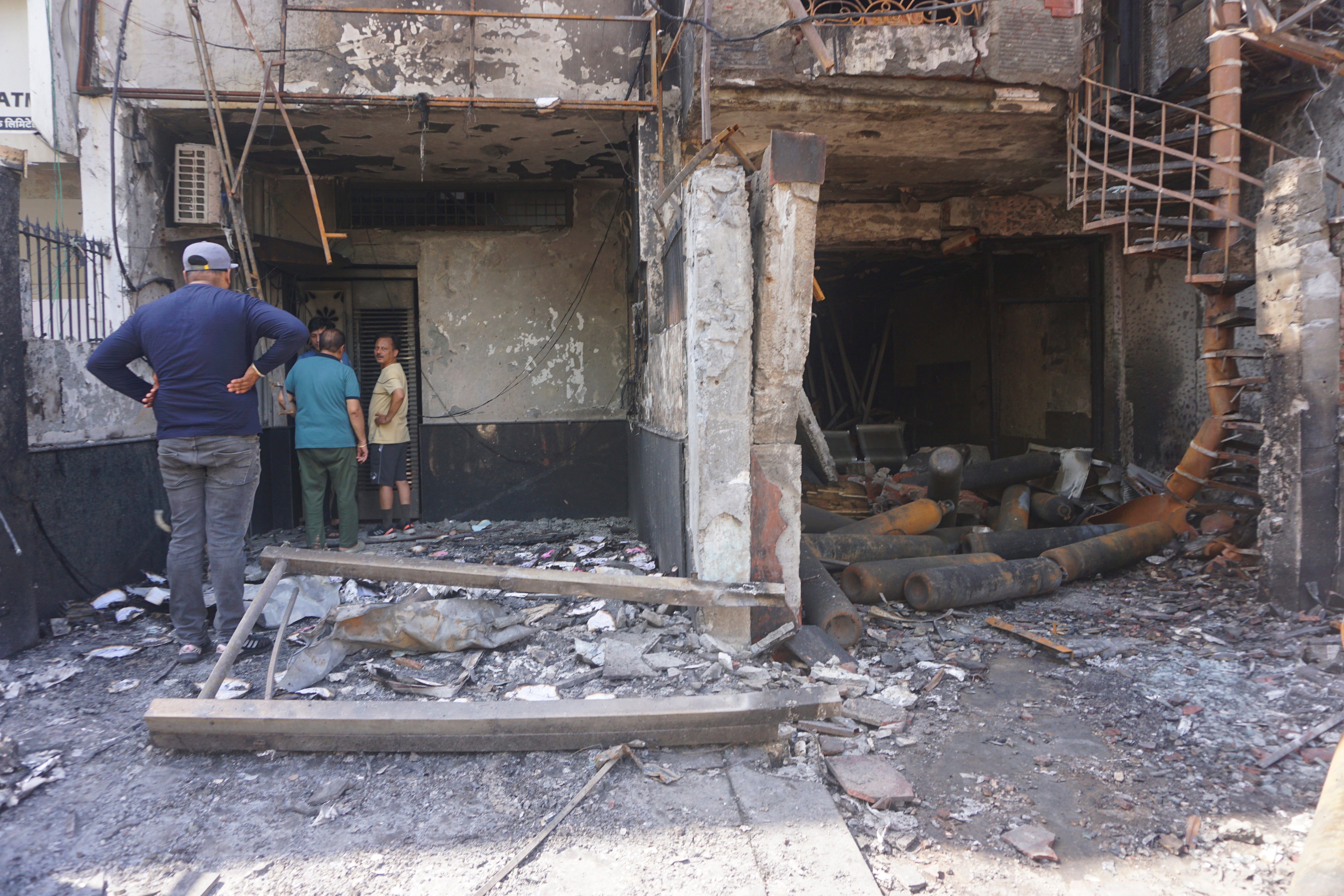 People look at the burnt building of a baby hospital in Delhi on Sunday