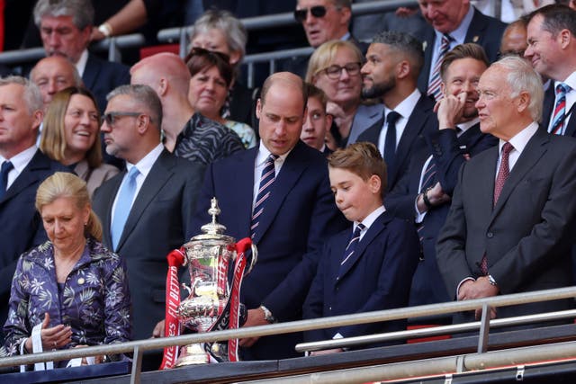 <p>Prince William and Prince George look at the FA Cup Trophy during the match between Manchester City and Manchester United at Wembley on Saturday </p>