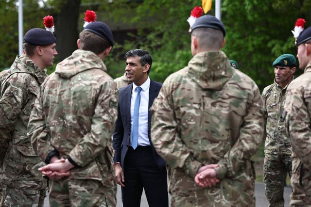 <p>Rishi Sunak speaks with British troops in April</p>
