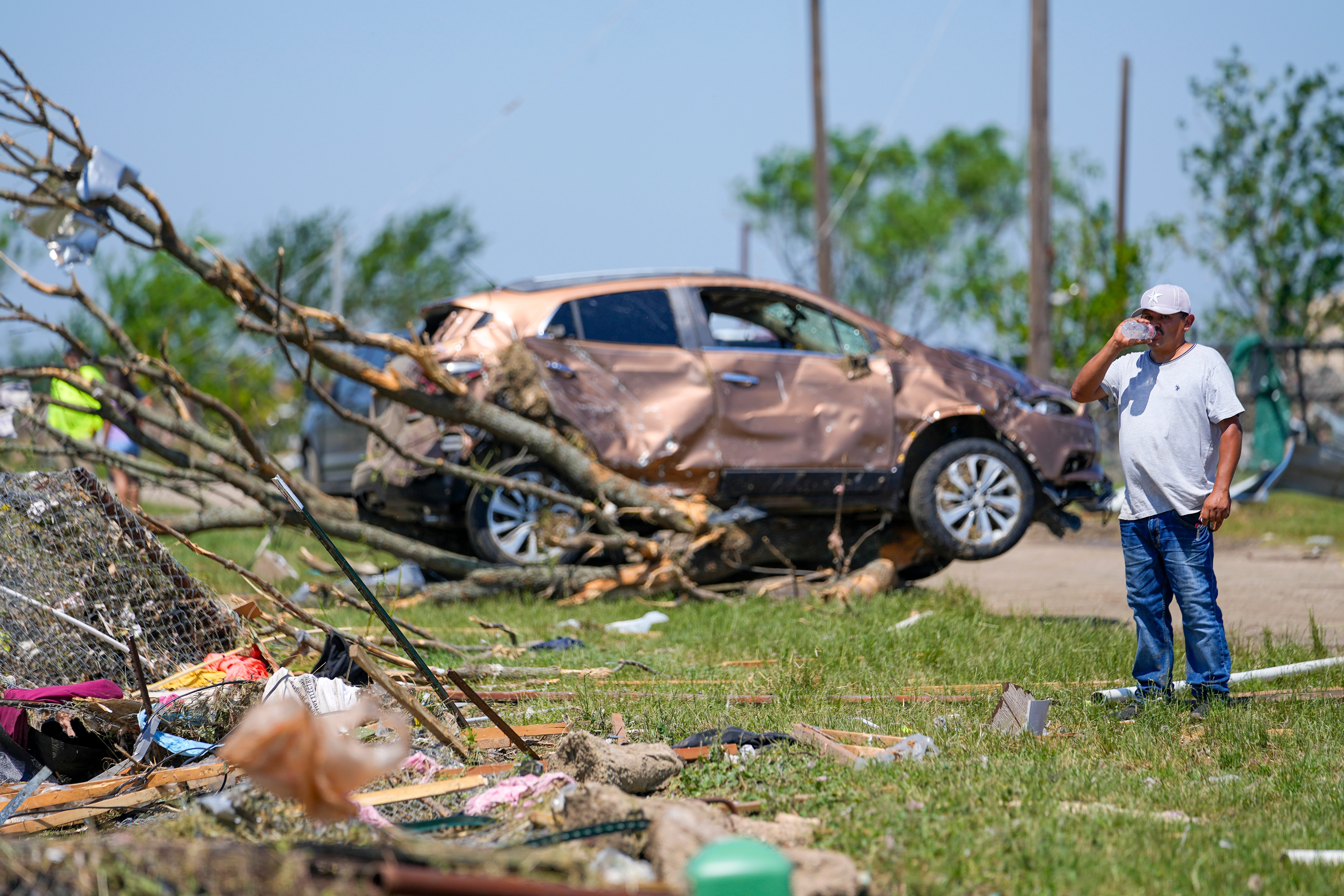 A man surveys damage to a neighbor's home after a deadly tornado ripped through Valley View, Texas