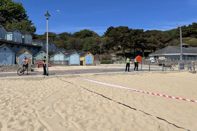 <p>Police officers at the scene of a fatal stabbing at Durley Chine Beach in Bournemouth</p>