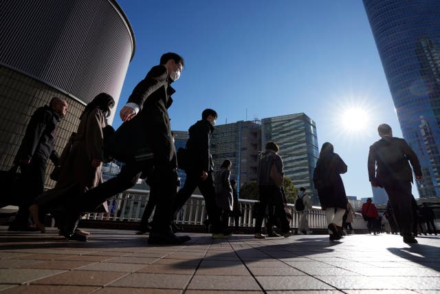 <p>Commuters walk in a passageway during a rush hour at Shinagawa Station</p>