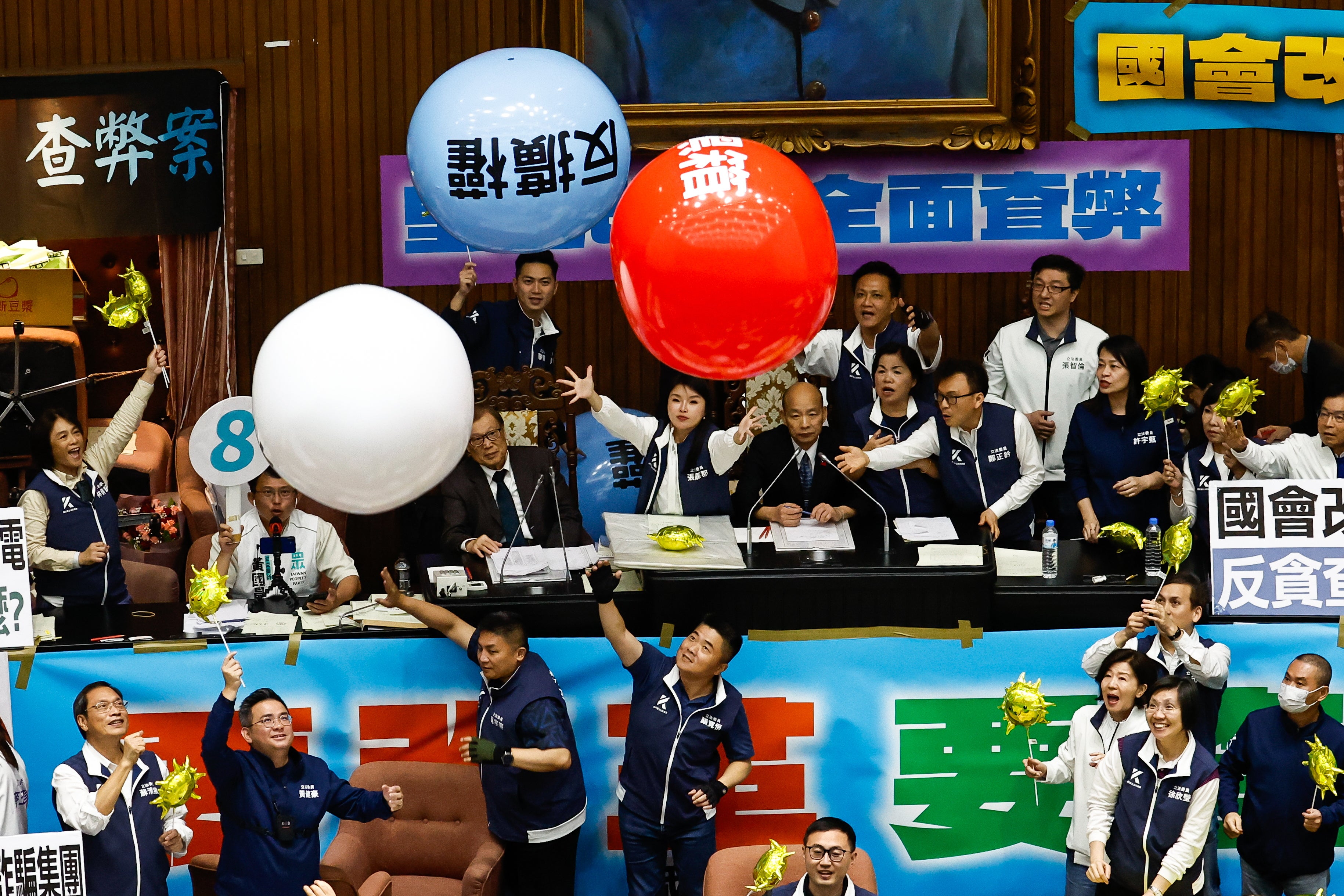 Taiwanese lawmakers from the Democratic Progressive Party throw inflatable balloons with words reading ‘anti evil laws’ at the Parliament President Han Kuo-yu, at the chamber inside the Legislative Yuan, in Taipei, Taiwan