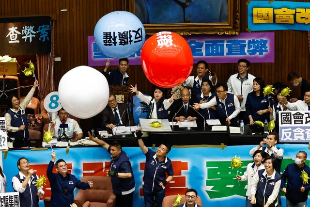 <p>Taiwanese lawmakers from the Democratic Progressive Party throw inflatable balloons with words reading ‘anti evil laws’ at the Parliament President Han Kuo-yu, at the chamber inside the Legislative Yuan, in Taipei, Taiwan</p>