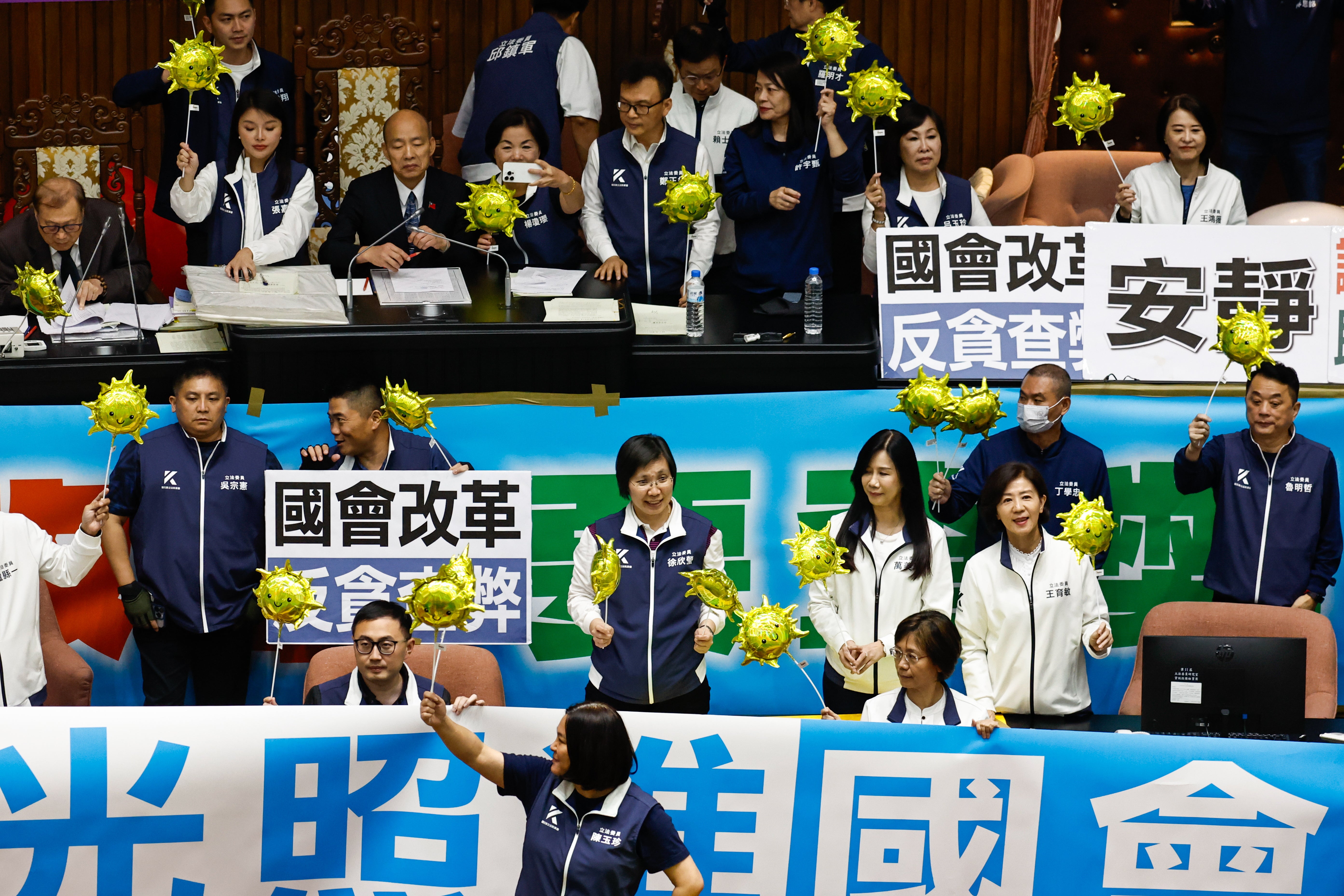 Taiwanese lawmakers of the Kuomintang (KMT) holding props stand near the Parliament President Han Kuo-yu to prevent the Democratic Progressive Party’s legislators from approaching, at the chamber inside the Legislative Yua