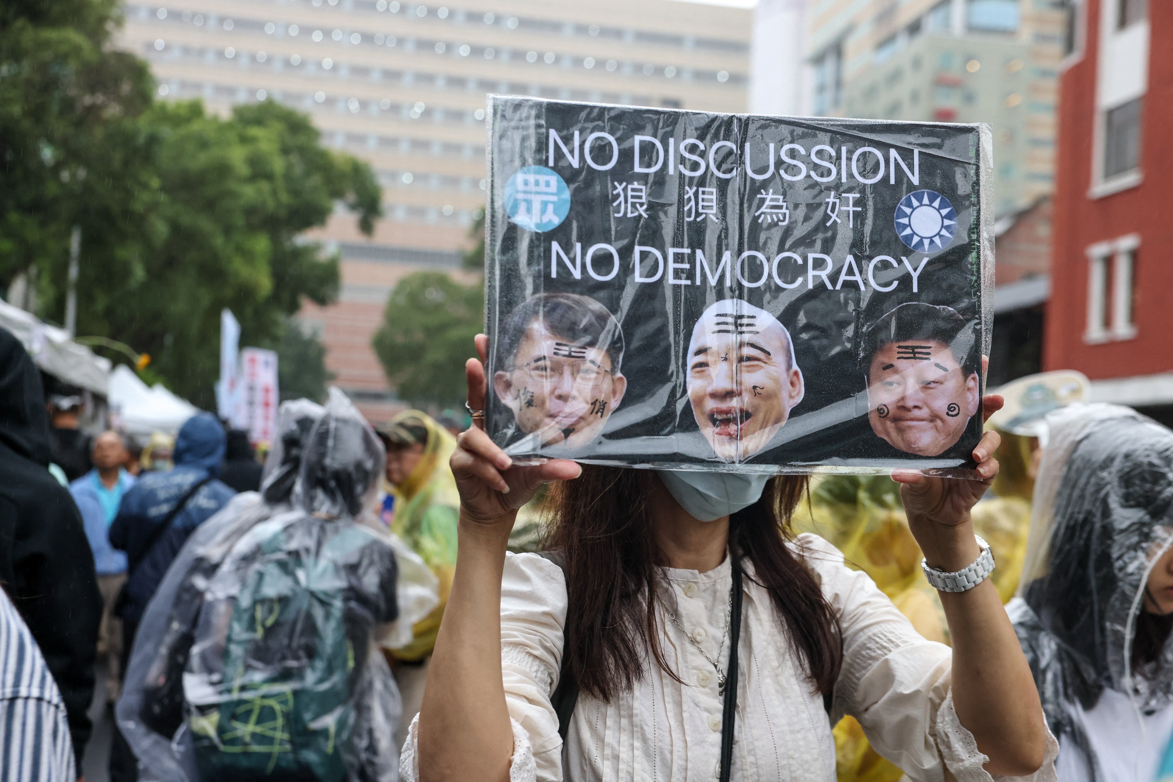 A protestor holds a sign reading "No discussion and no democracy" during the vote for the Parliament reform bill outside of Legislative Yuan in Taipei