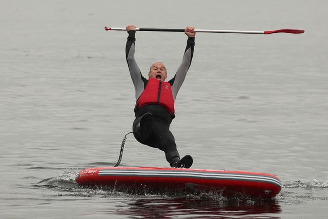 <p>Ed Davey falls from a paddleboard on Lake Windermere as he unveils the Liberal Democrat message on sewage in Britain’s waters</p>