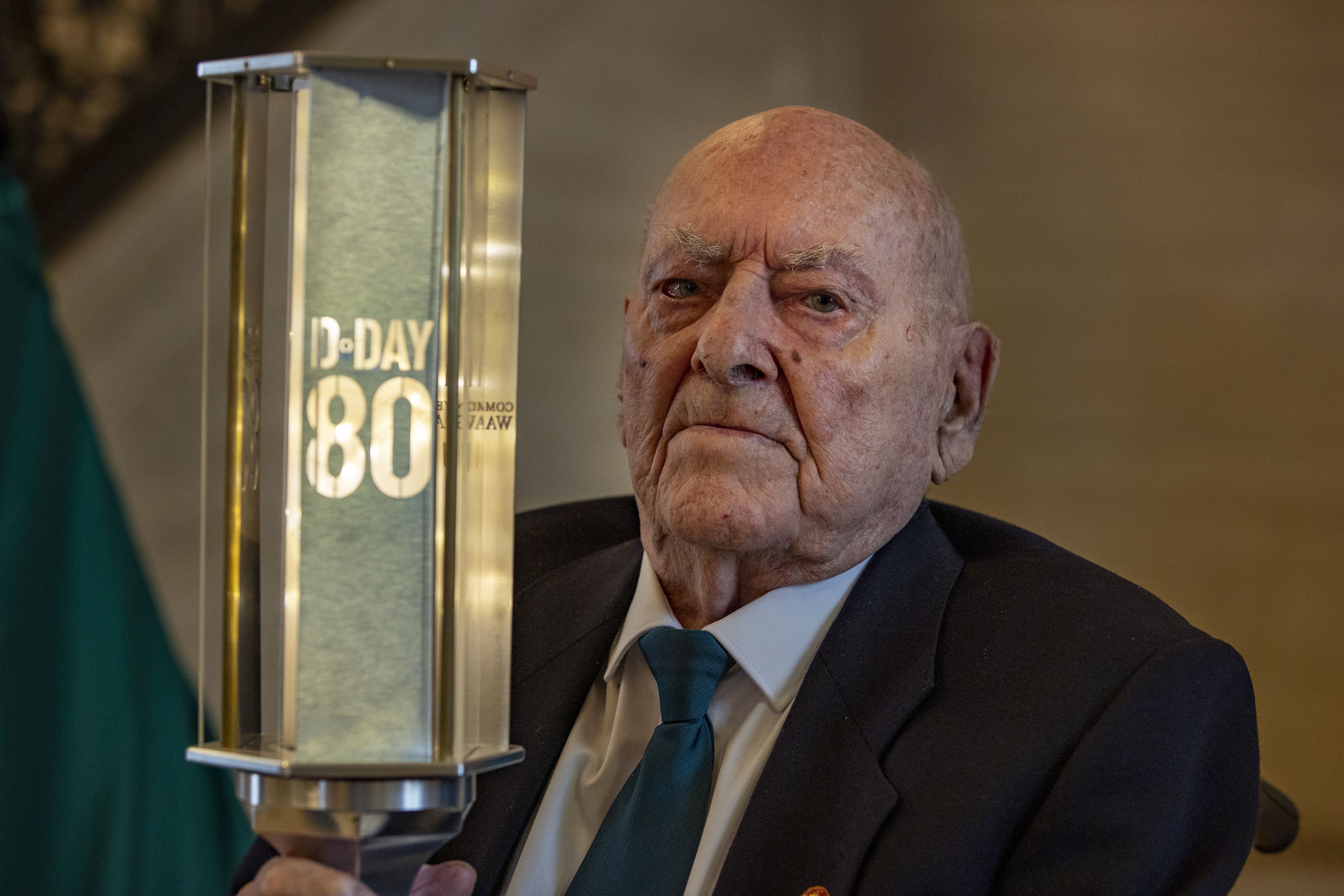 Veteran George Horner holds the D-Day 80 torch of commemoration in the Great Hall at Parliament Buildings at Stormont (Liam McBurney/PA)