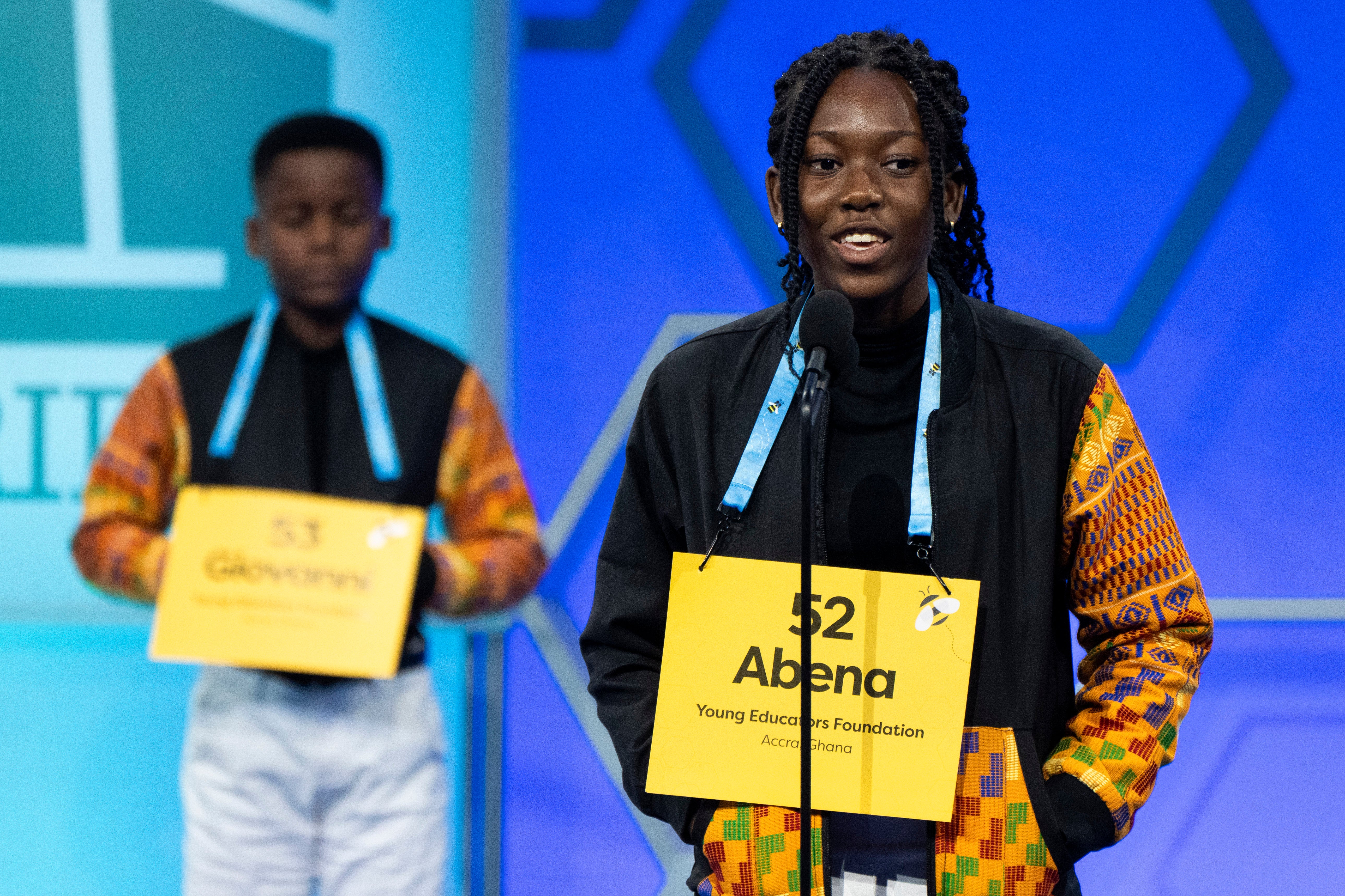 Wearing coordinating jackets, Abena Kwaffo, 13, of Accra, Ghana, right, spells her word as Giovanni Adjei, 10, of Accra, Ghana, waits for his turn, during competition in the Scripps National Spelling Bee, in Oxon Hill, May 28, 2024