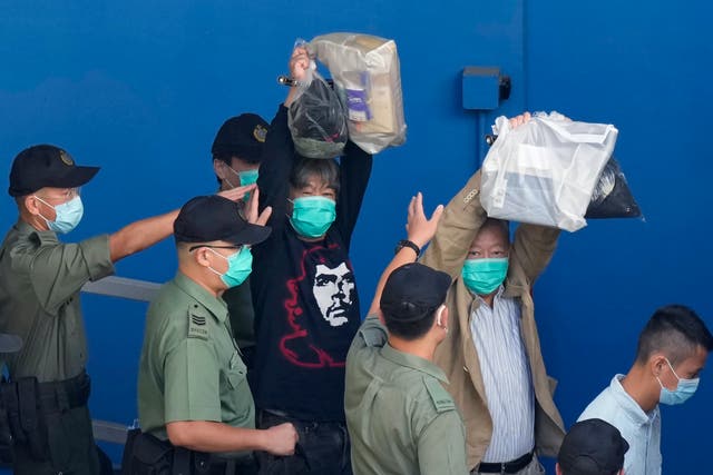 <p>Activists are escorted to a prison van for a court hearing in Hong Kong on 28 May 2021</p>