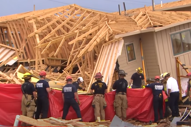 <p>Rescue crews stand outside a collapsed home in Magnolia County, Texas on Tuesday</p>