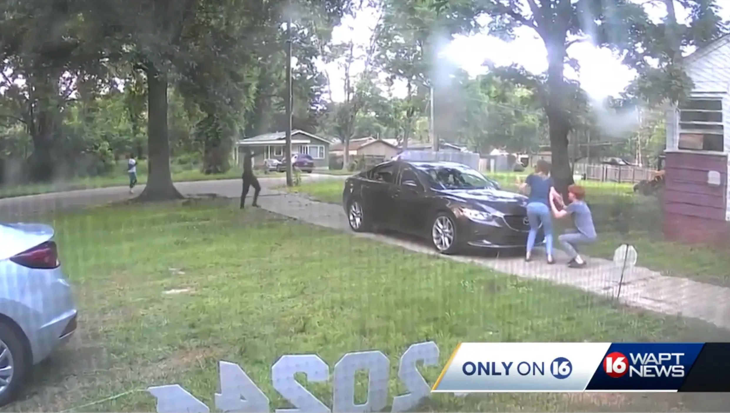 Heather Allen and her son duck behind a car as two men walk up their driveway with guns