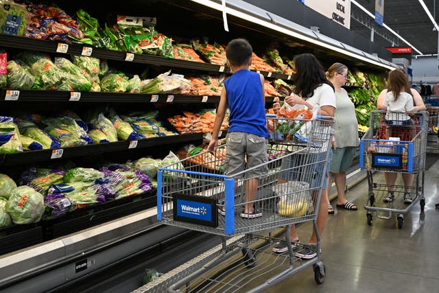 <p>Shoppers pictured buying produce at Walmart. Store brands, like Walmart’s Great Value, are becoming increasingly popular amid high national brand prices</p>