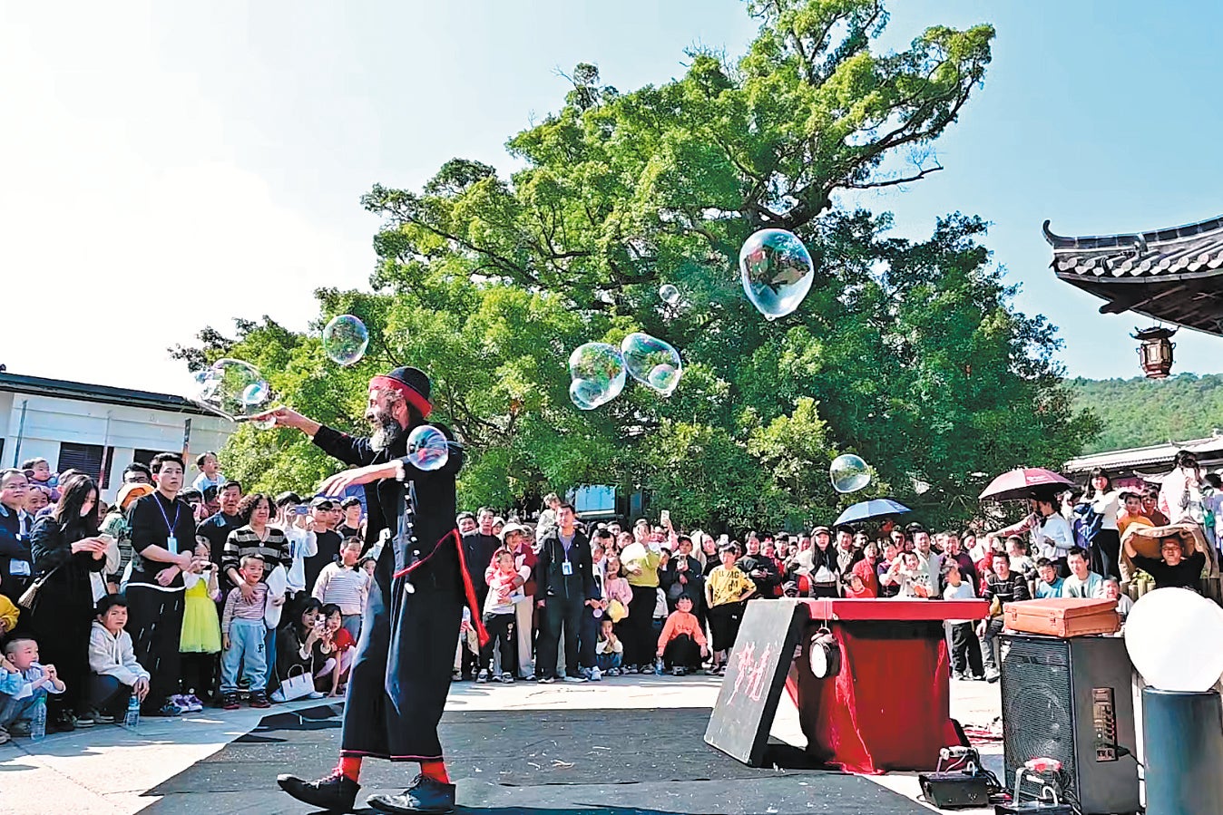 An artist from Italy presents a bubble show during the grand opening of the theatre village in January