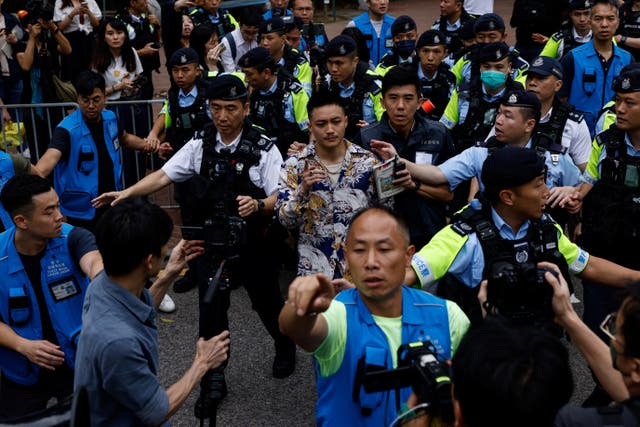<p>Lee Yue-shun is escorted by police outside the West Kowloon Magistrates' Courts building after being acquitted of charges under the national security law, in Hong Kong</p>