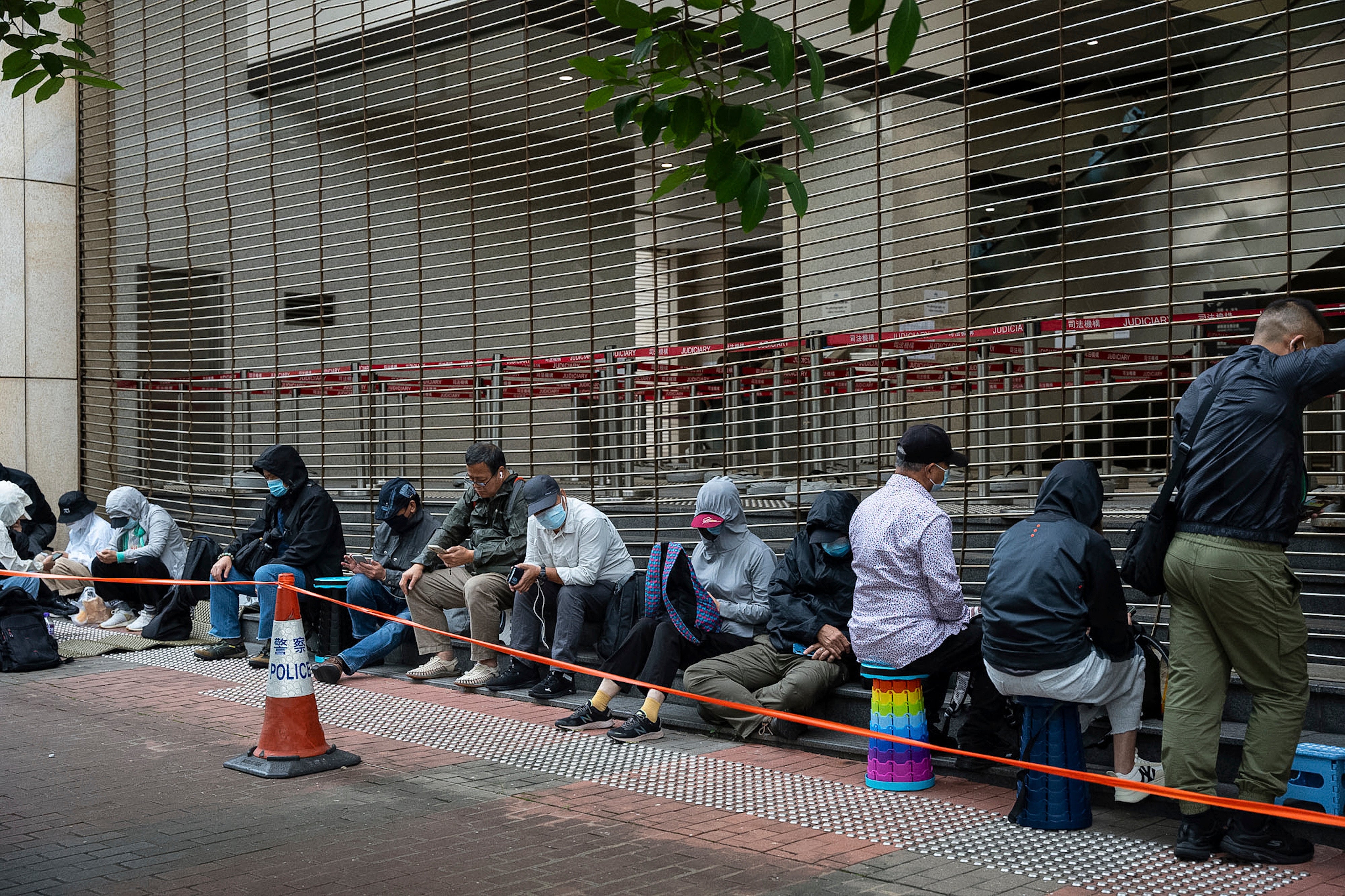 People wait in line outside the West Kowloon Magistrates' Courts in Hong Kong, Thursday