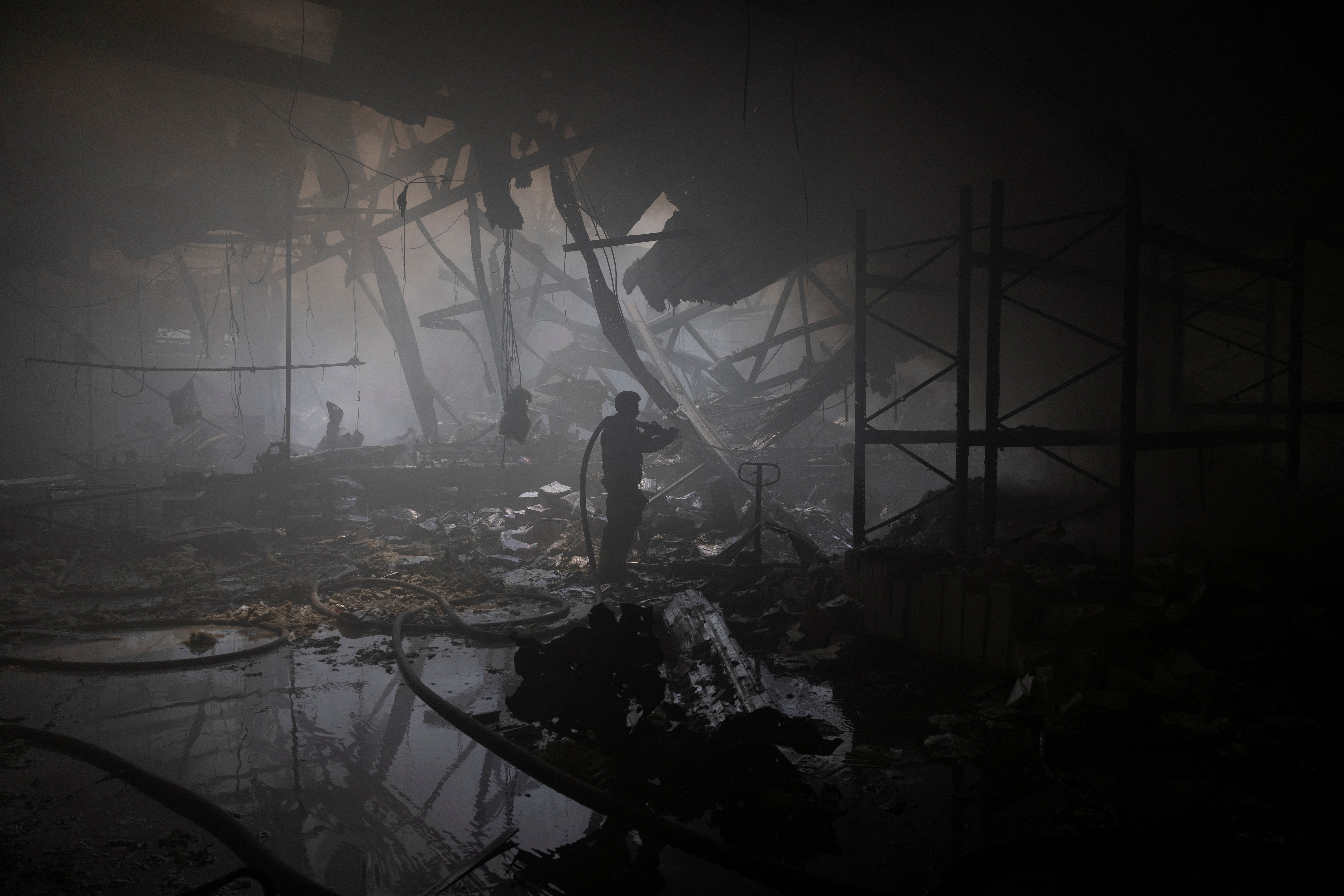 A firefighter works at the site where a printworks was hit by Russian missile strikes, amid Russia’s attack on Ukraine, in Kharkiv, Ukraine 23 May 2024