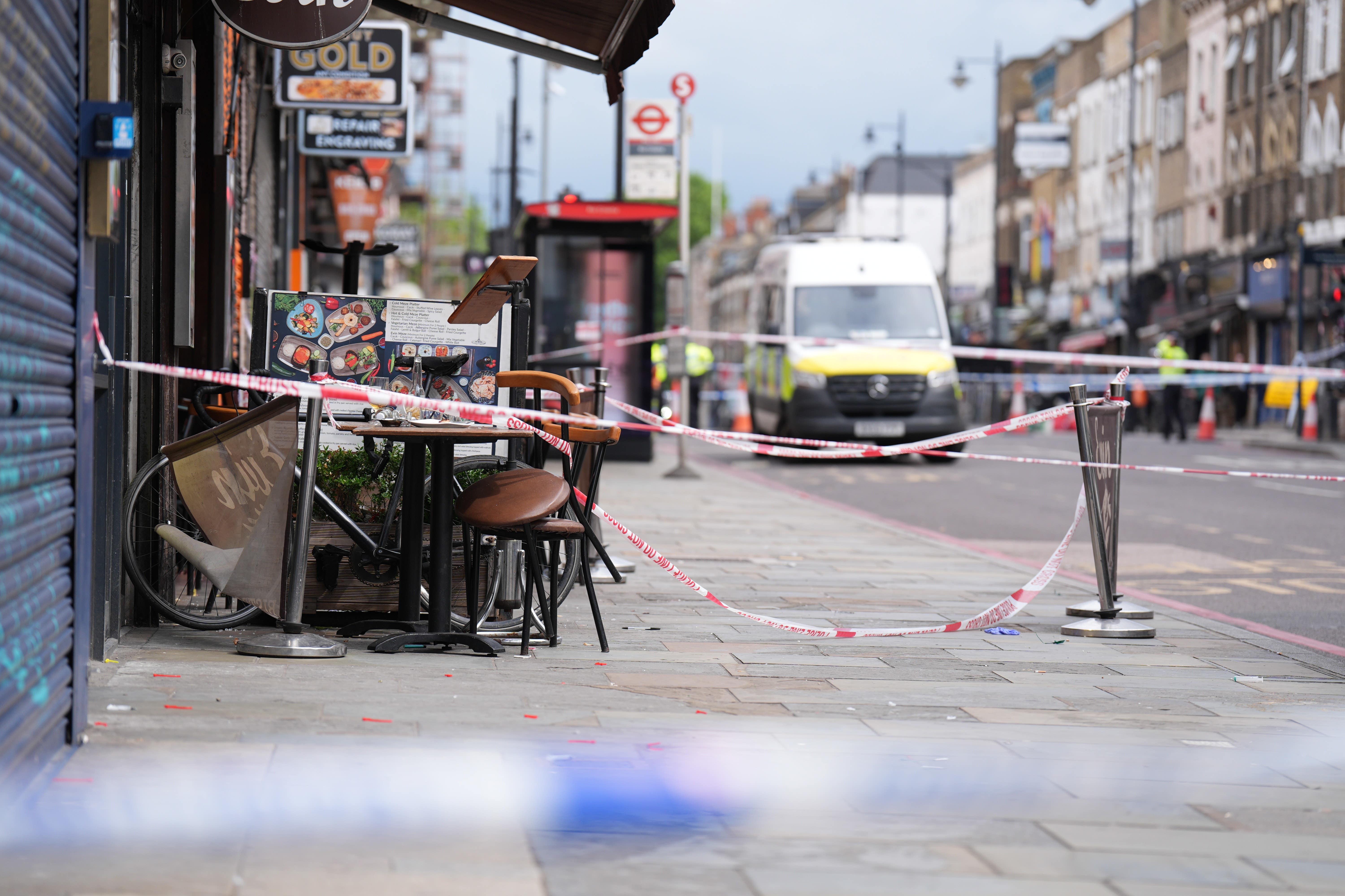 Police at the scene of a shooting at Kingsland High Street, Hackney, east London, where three adults and a child have been injured (James Manning/PA)