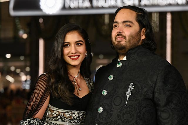 <p>Anant Ambani (R), son of Indian businessman Mukesh Dhirubhai Amani, and fiancee Radhika Merchant pose for pictures during the inauguration of the Nita Mukesh Ambani Cultural Centre (NMACC) at the Jio World Centre (JWC) in Mumbai</p>