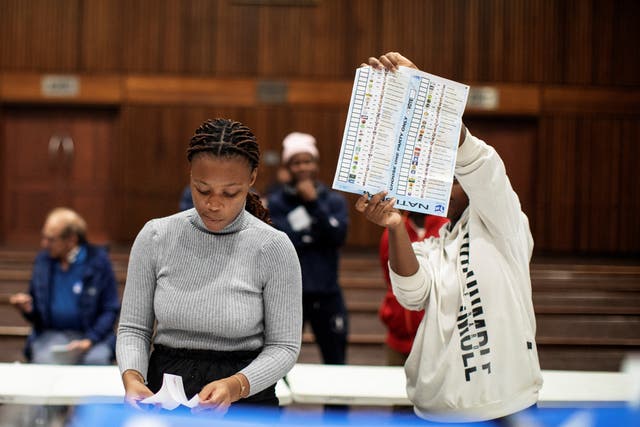 <p>An Electoral Commission of South Africa (IEC) official holds up a marked ballot during the vote counting process</p>